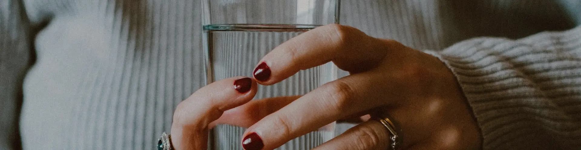 Frau mit einem Glas Wasser in der Hand