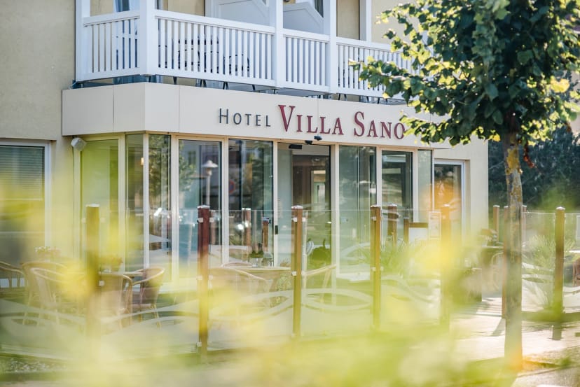 Eingangsbereich des Hotels Villa Sano mit Schriftzug und verglaster Front