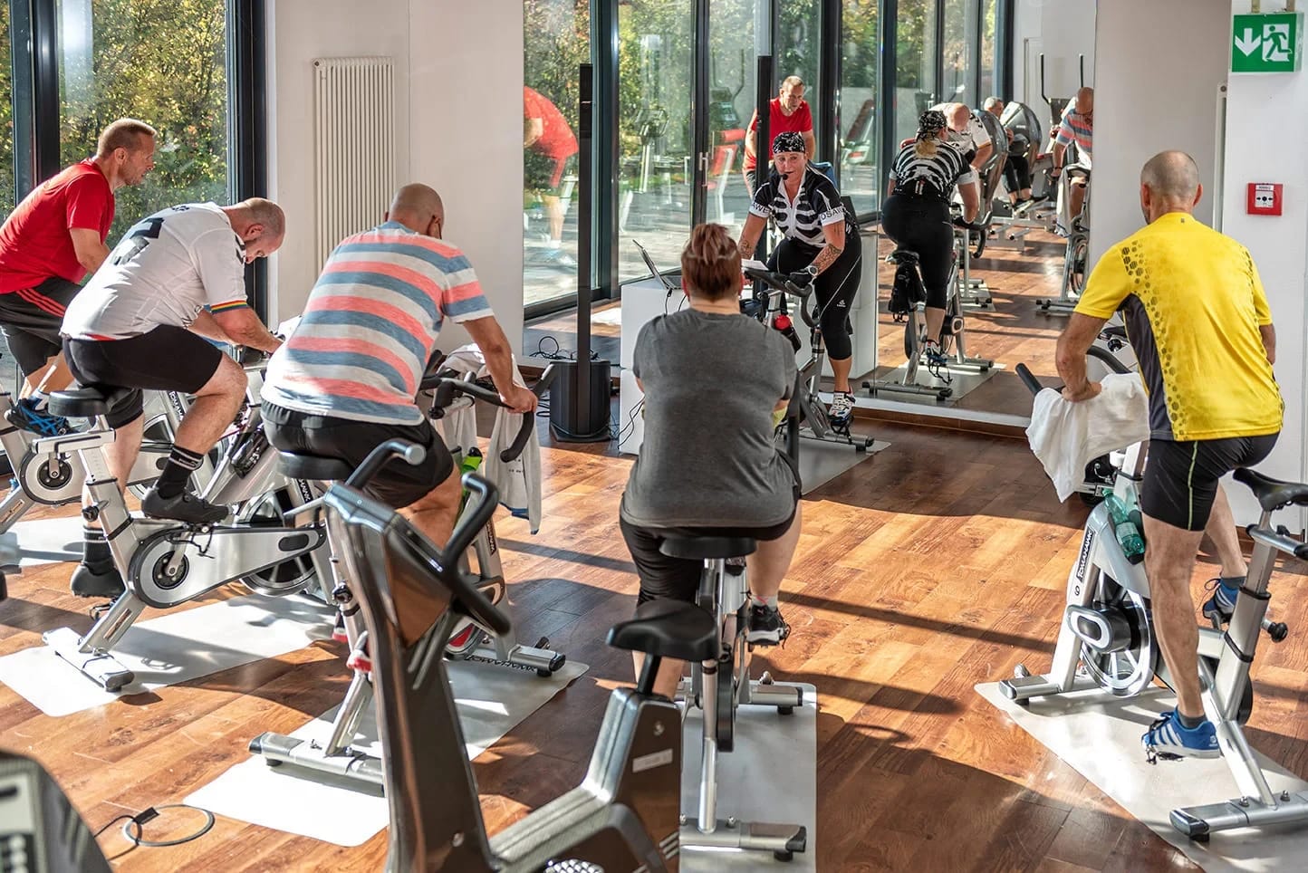 Fitnessraum mit Spinning-Rädern vor bodentiefen Fenstern