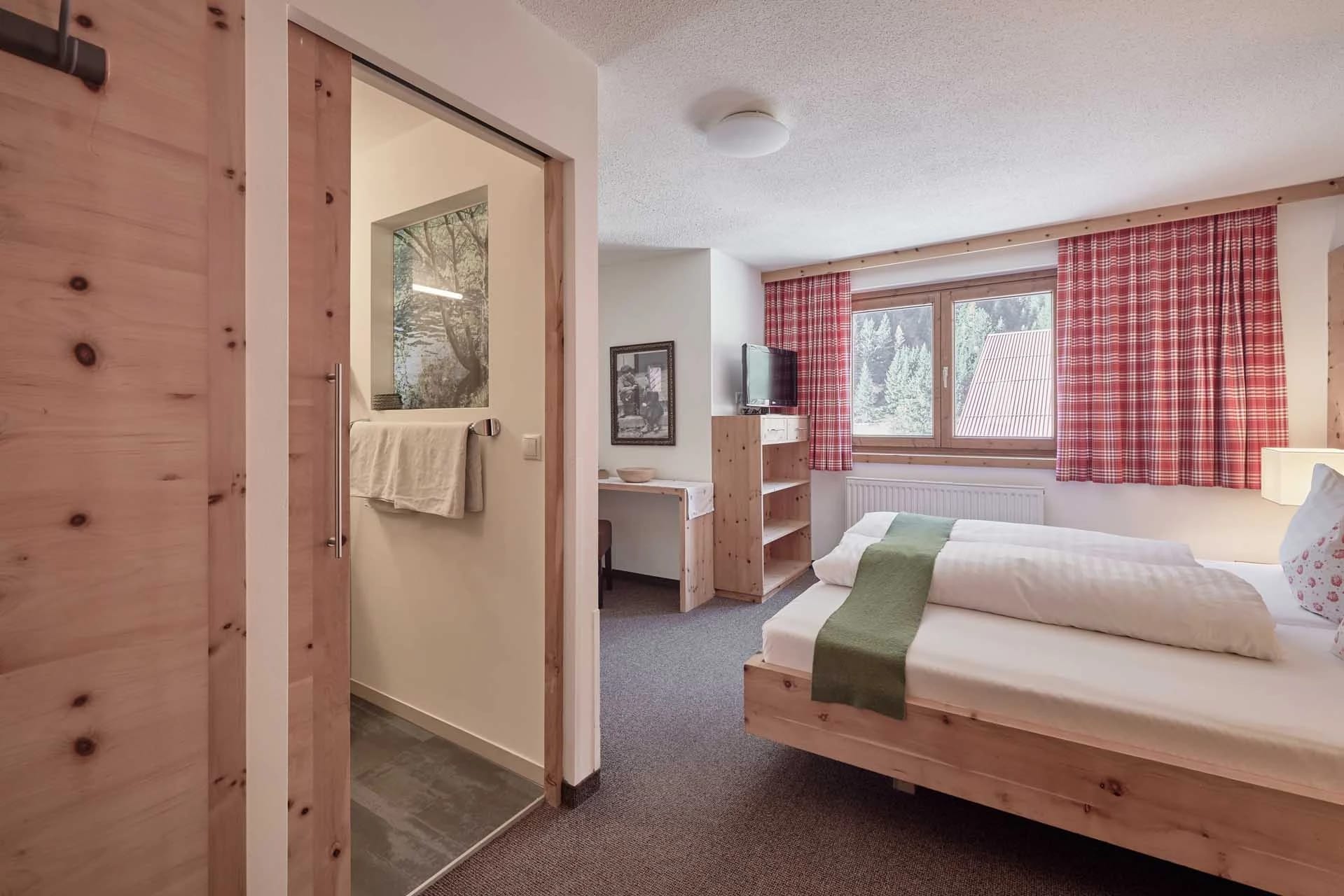 Helles, geräumiges Zimmer mit Zirbenholzmöbeln, Doppelbett und Sitzbereich