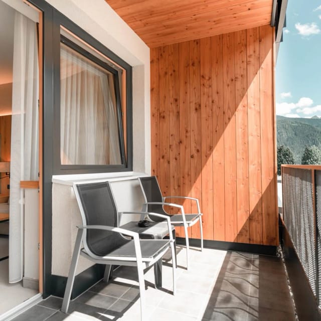 Zimmerbalkon mit Sitzgelegenheit und Blick auf die Berge