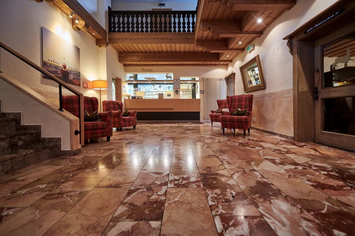 Hotellobby mit Marmorboden, Sesseln und Rezeption im Hintergrund