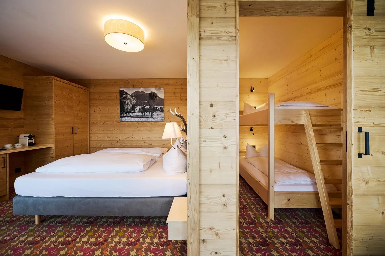 Familienzimmer mit Doppelbett und Stockbett hinter einer Holzwand