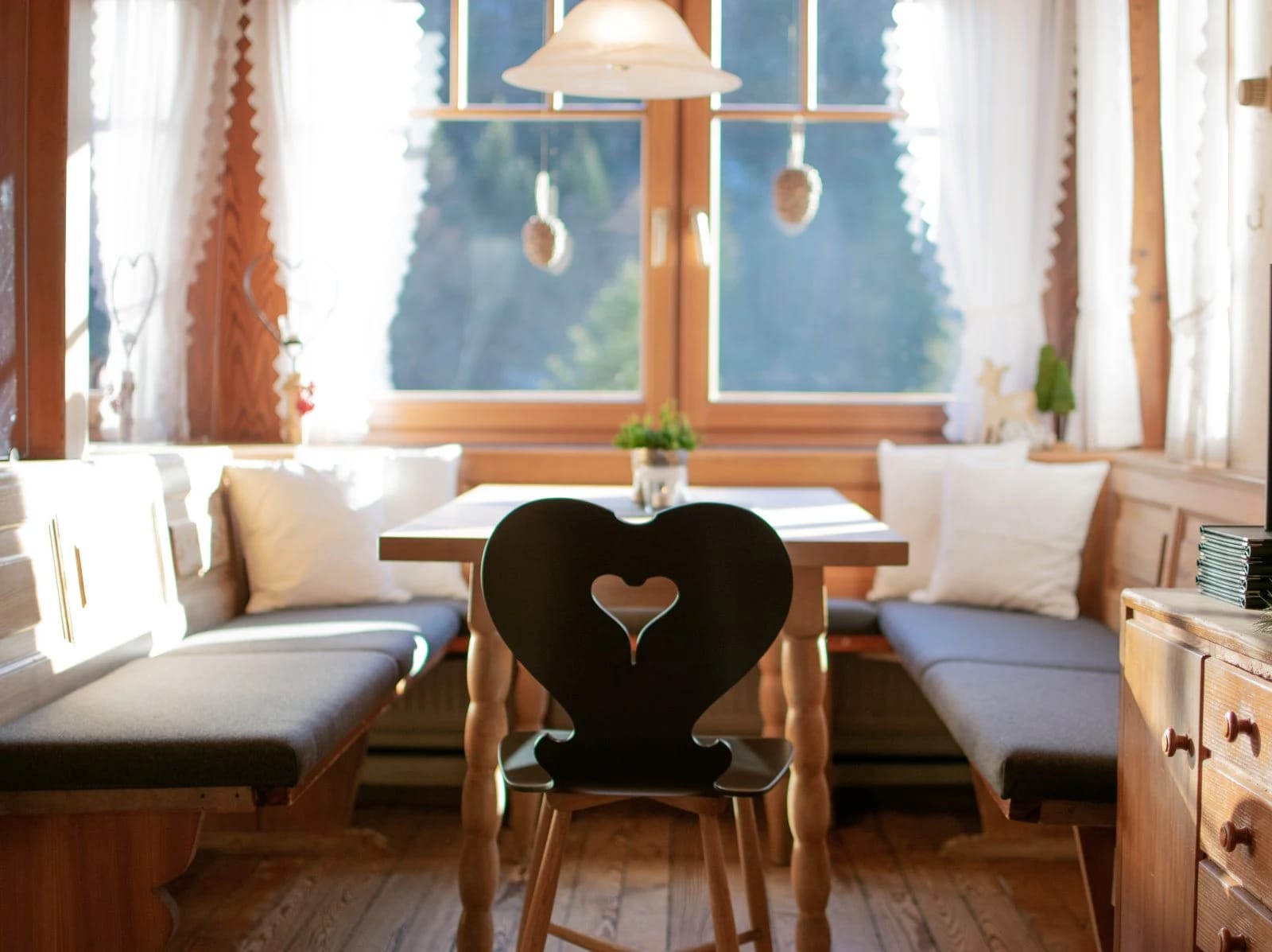 Gemütliche Stube mit Herz-Stuhl und sonnigem Fenster