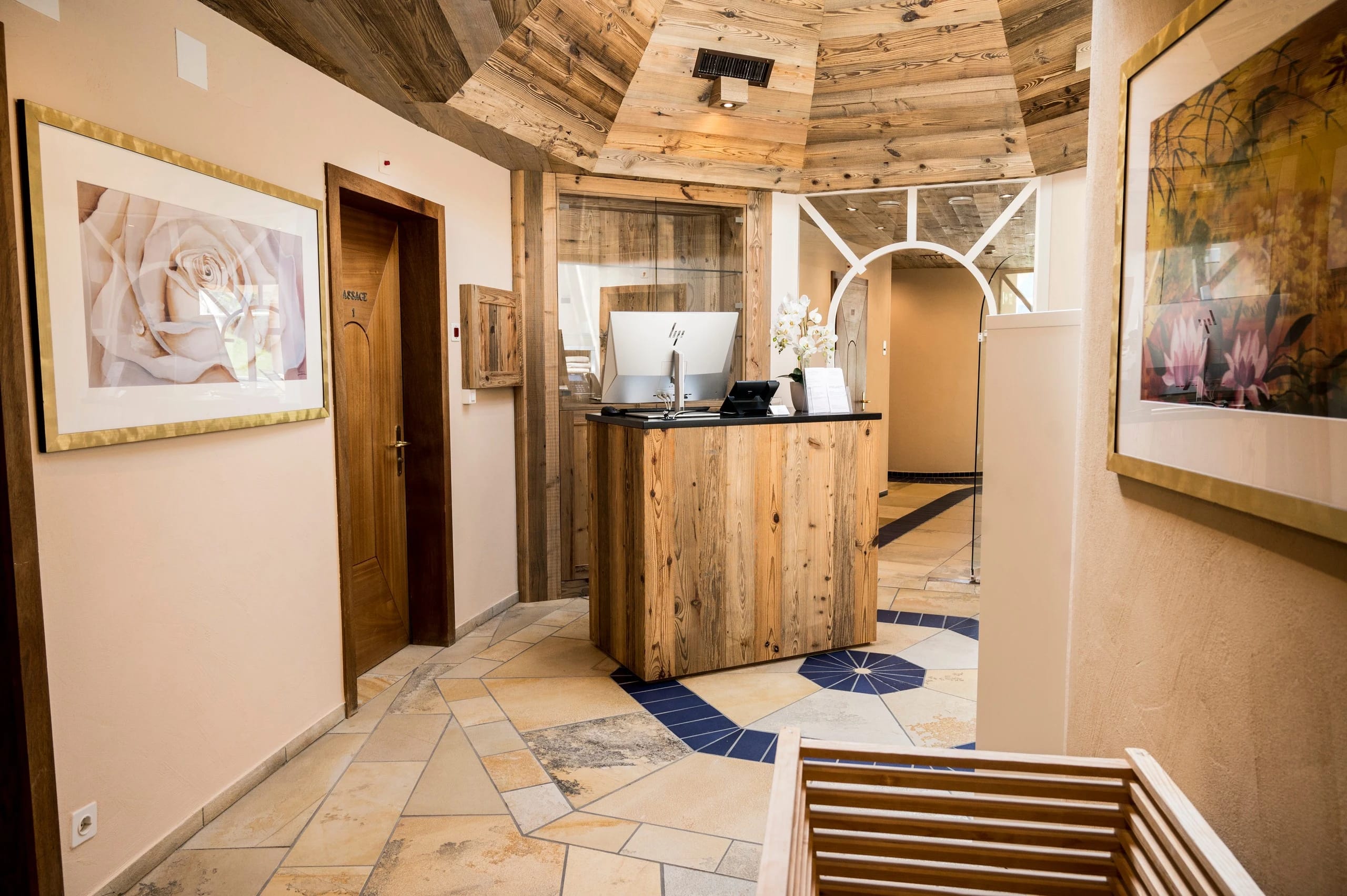 Spa-Empfang mit Altholztresen, Natursteinboden und gewölbter Holzdecke
