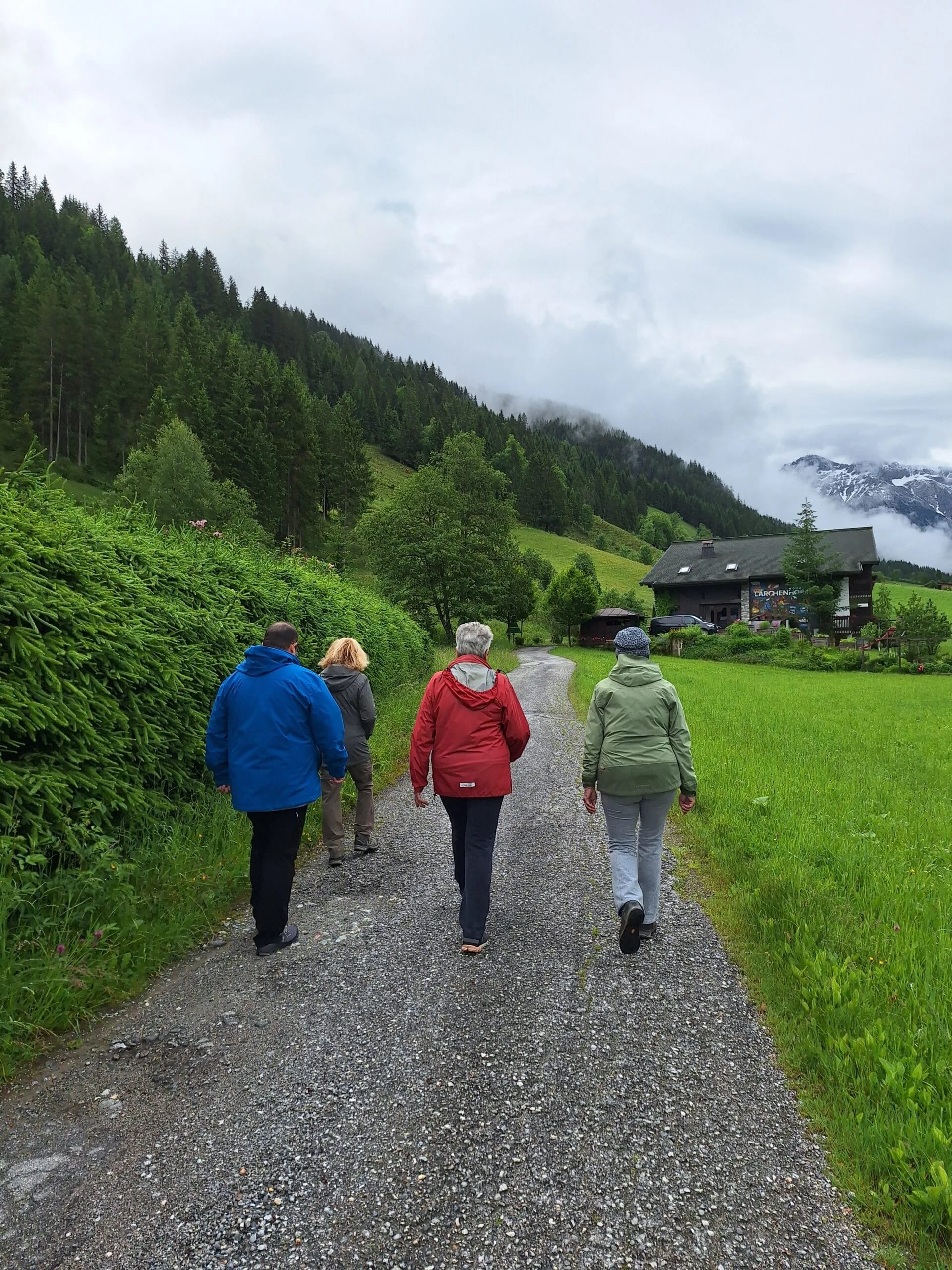 Fastenwandergruppe auf einem Schotterweg in den Bergen