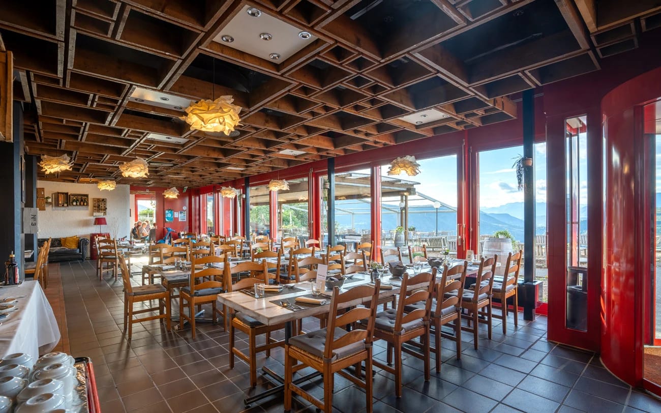Restaurantsaal mit kassettierter Holzdecke, roten Säulen und Panoramafenstern