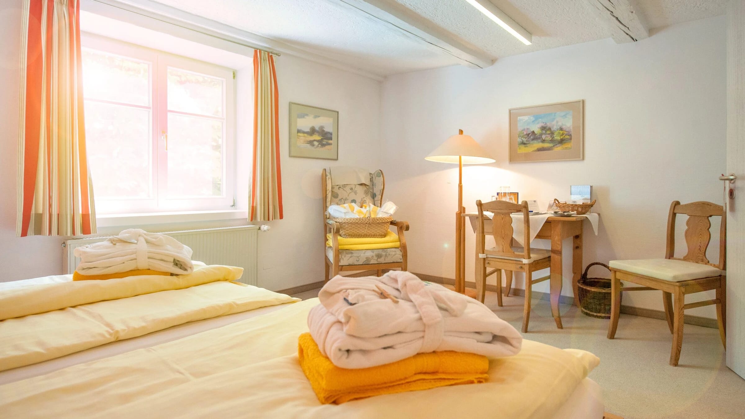 Zimmer mit zwei Betten, Sitzecke mit Tisch und Stühlen am Fenster