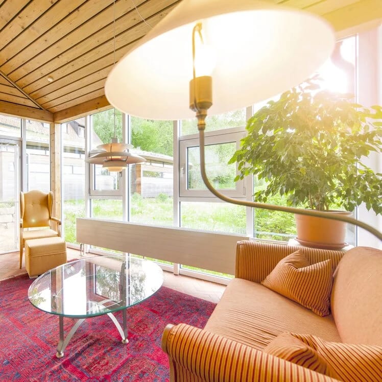 Loungebereich mit Polstersofa und Glasfront zum Garten
