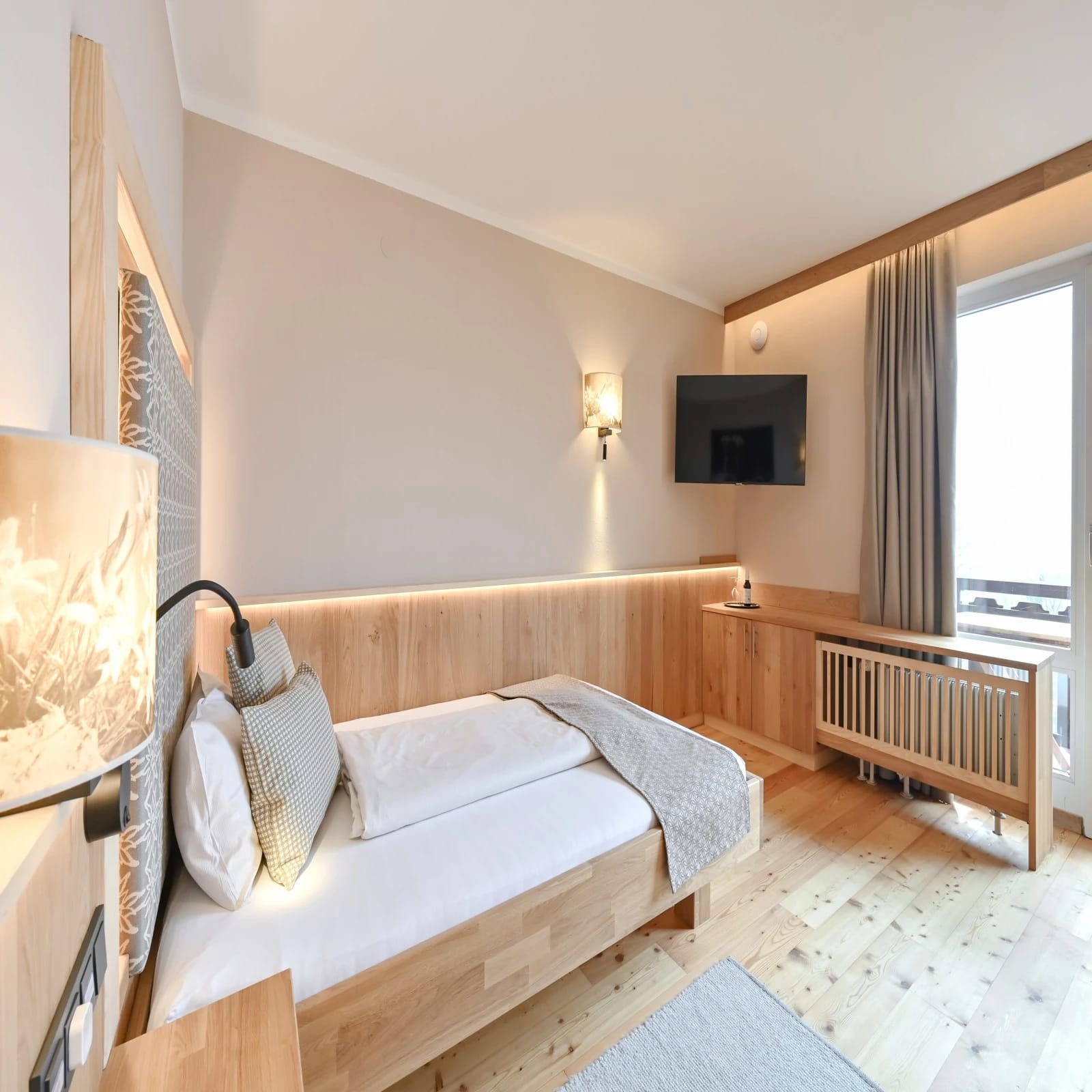 Modernes Hotelzimmer mit Doppelbett, Holzvertäfelung und Flachbildfernseher