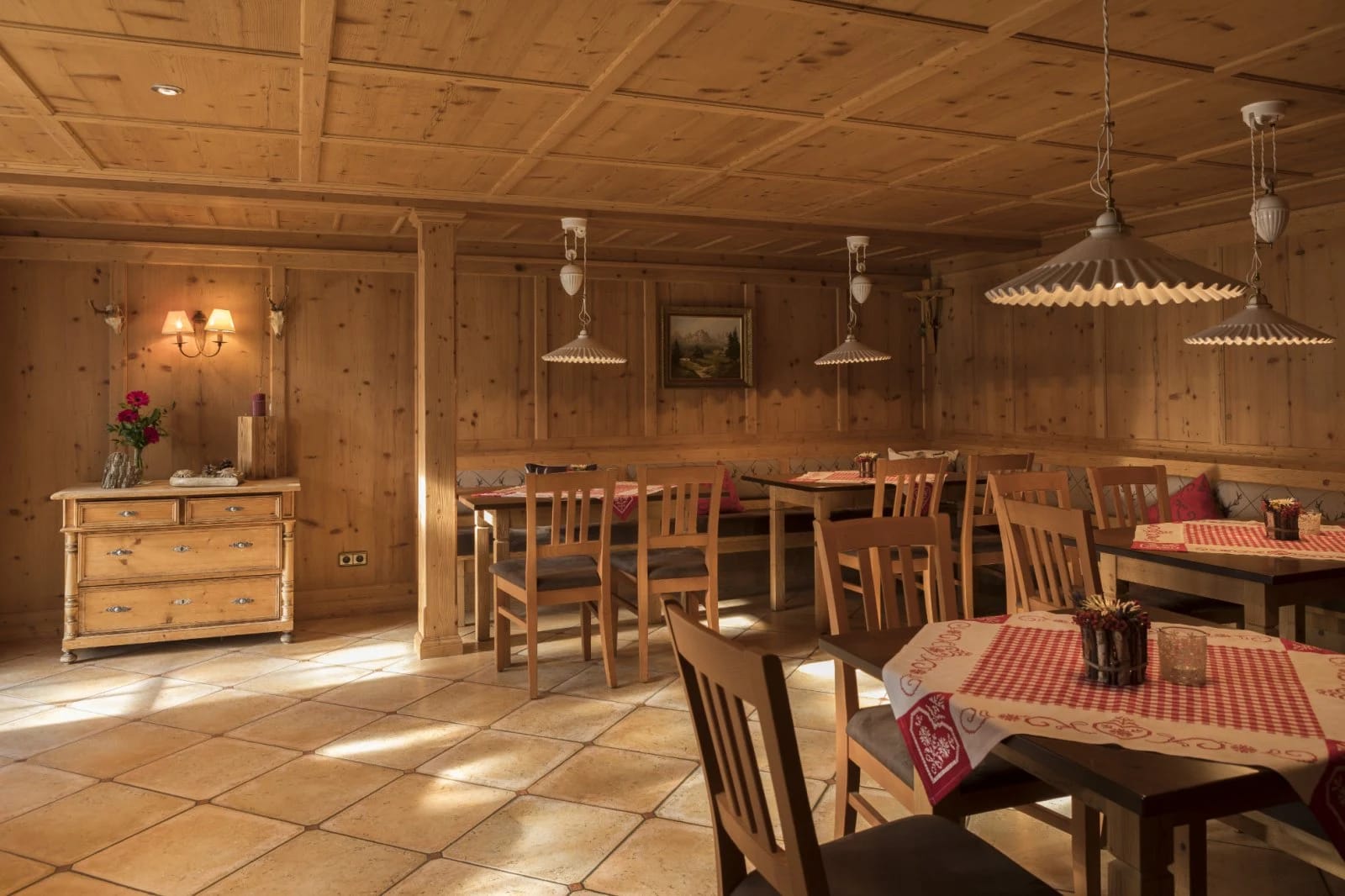 Holzgetäfelte Stube mit Tischen, Eckbank und Hängelampen