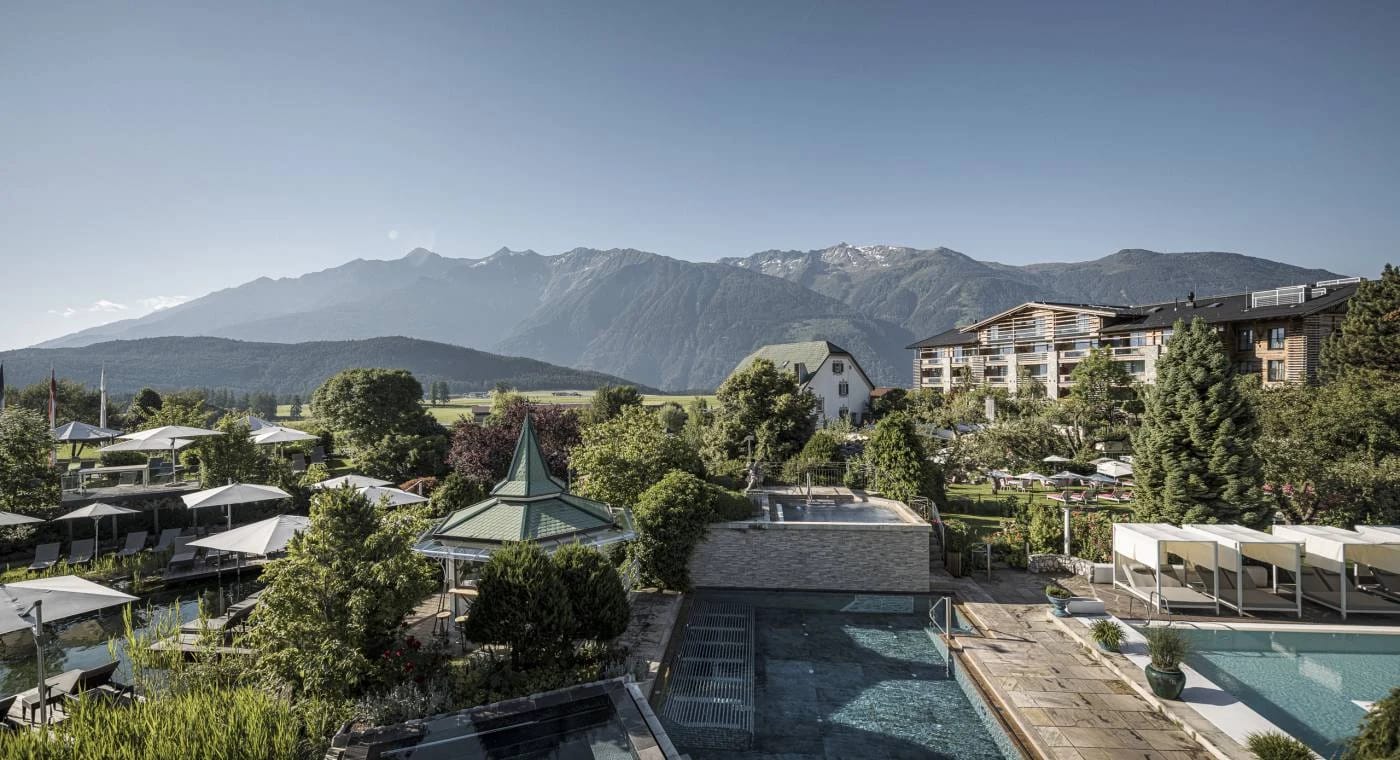Panoramablick über die Wellness- und Poolanlage mit Bergen