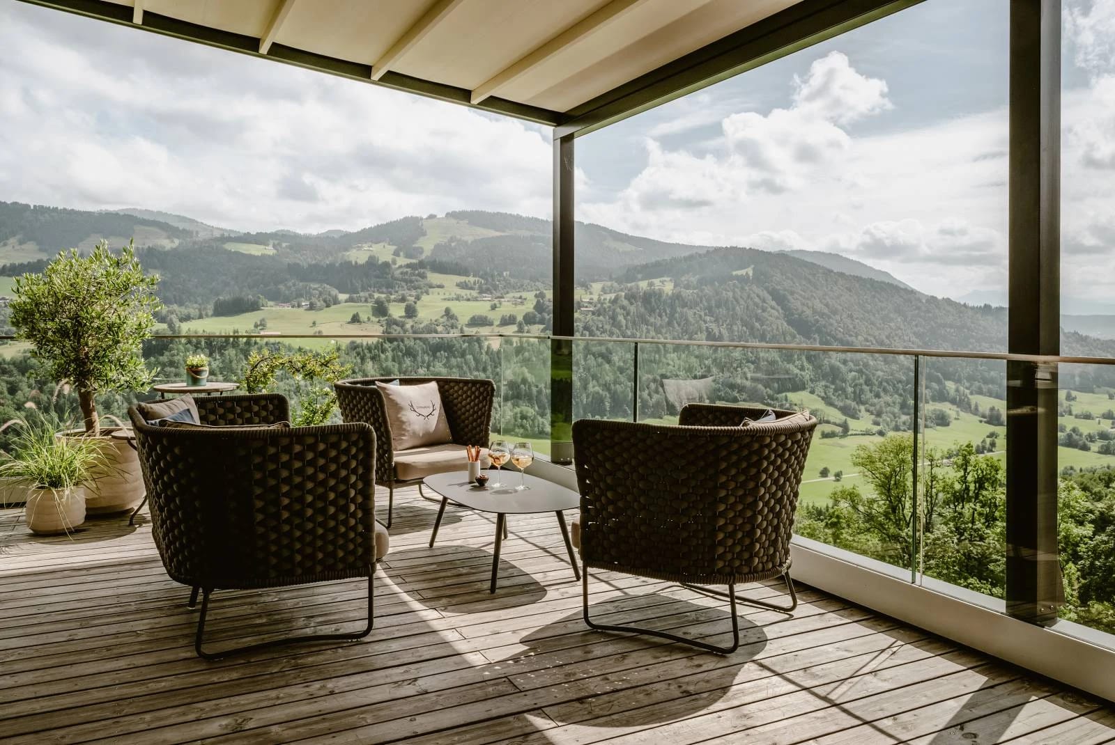 Sonnenterrasse mit Loungesesseln und Blick über die Berge