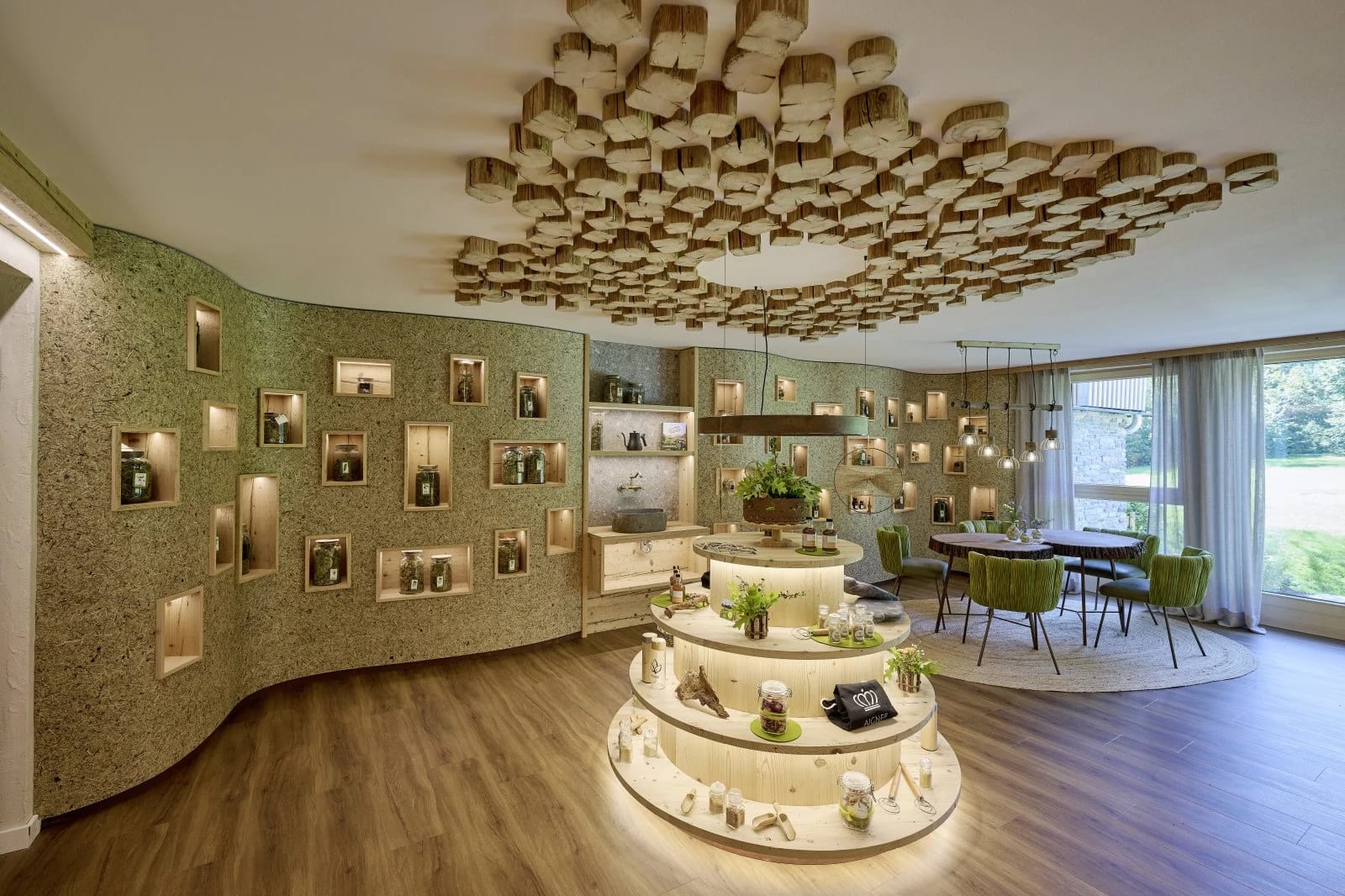 Empfangsbereich mit rundem Tresen, beleuchteten Wandnischen und Holzinstallation an der Decke