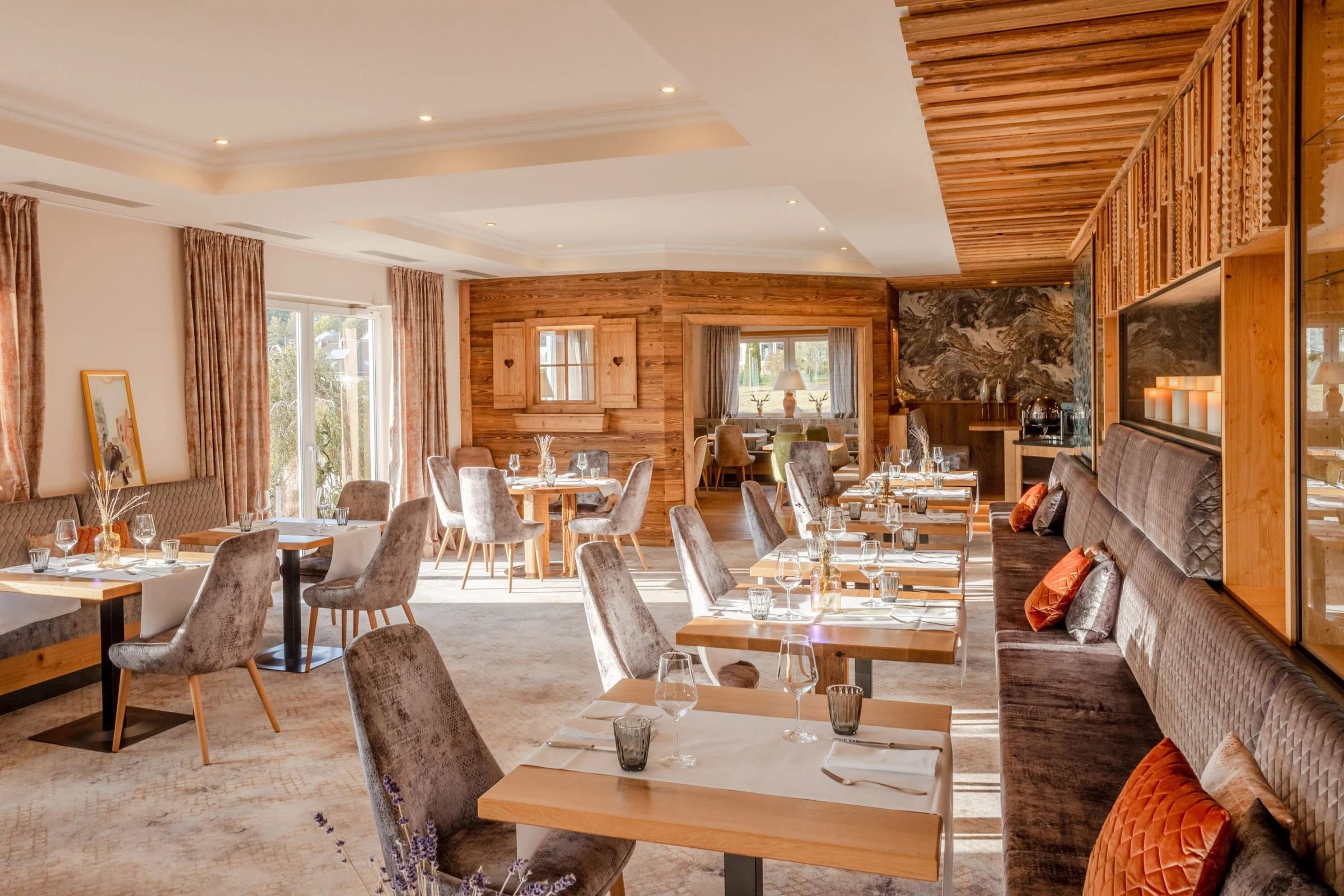 Heller Restaurantbereich mit gepolsterten Stühlen und Fenstern zum Garten