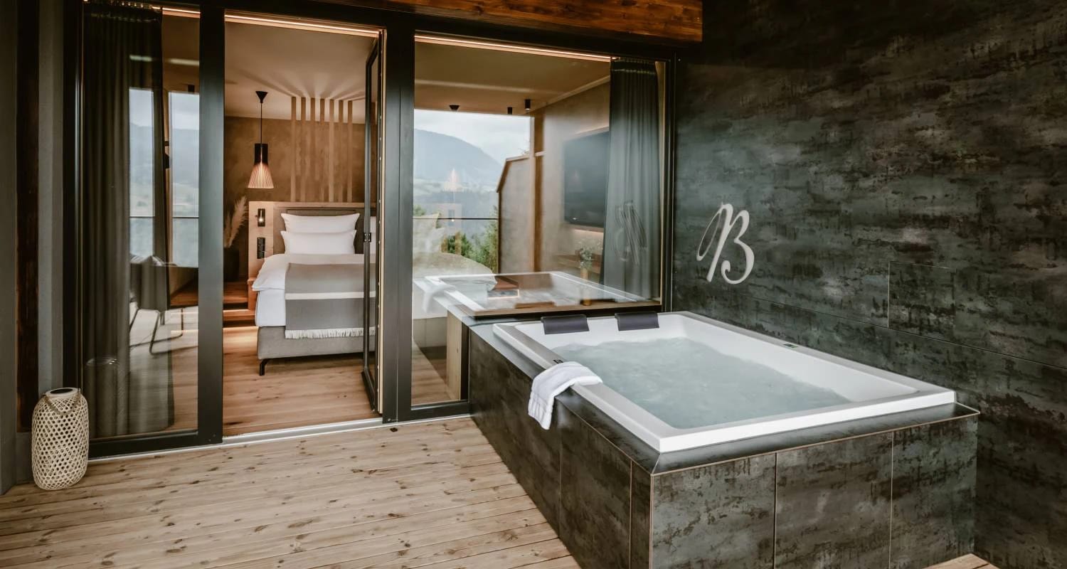 Whirlwanne auf der Terrasse einer Suite mit offenem Zugang zum Schlafbereich