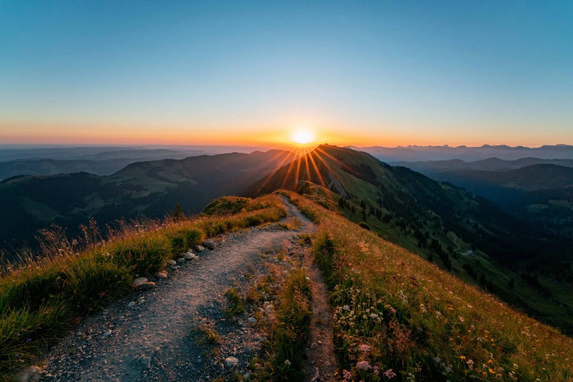Wanderweg auf einem Bergrücken bei Sonnenuntergang mit Blick über die Allgäuer Berge