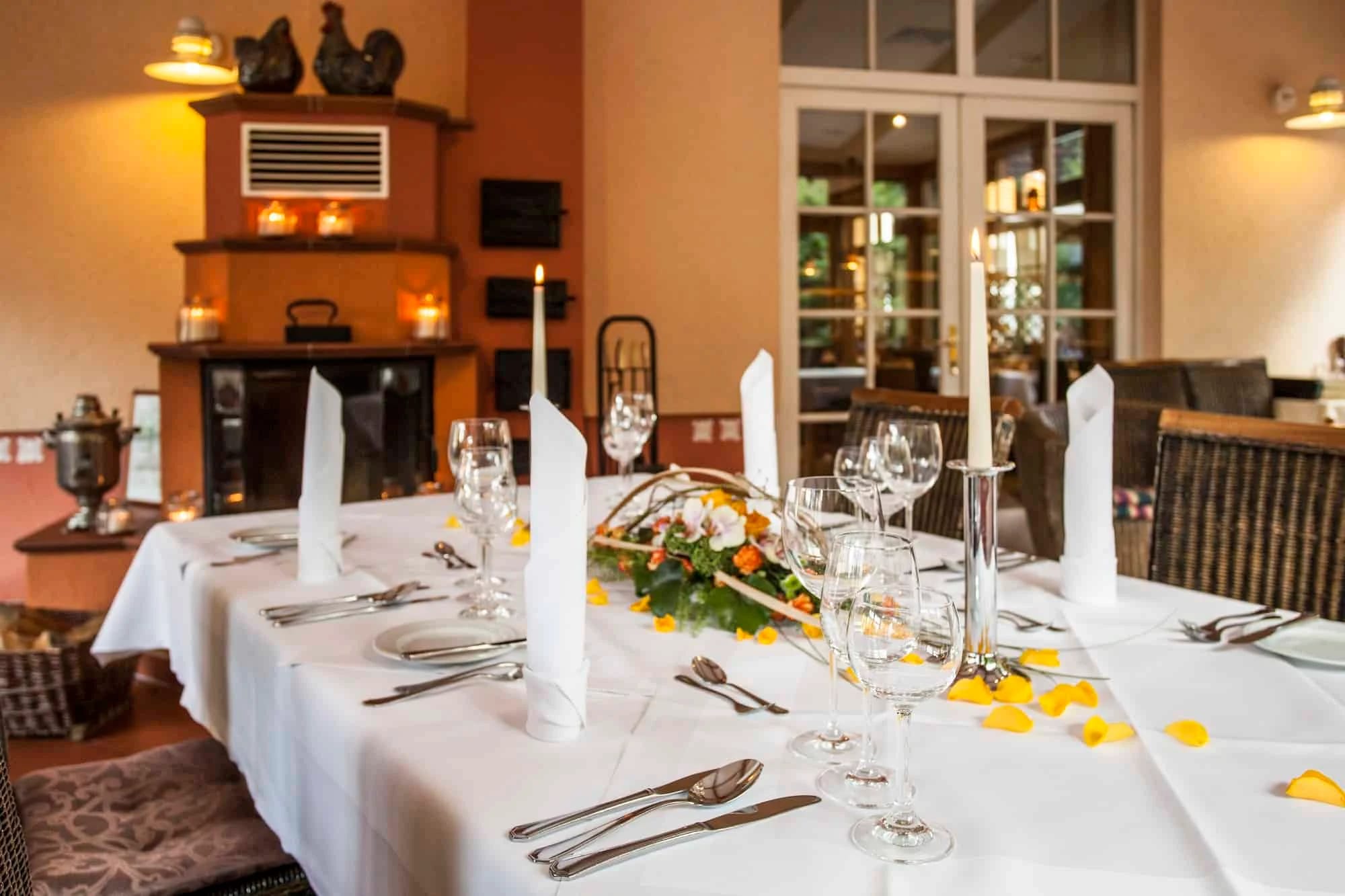 Festlich eingedeckter Tisch im Restaurant mit Kerzen und Blumenschmuck
