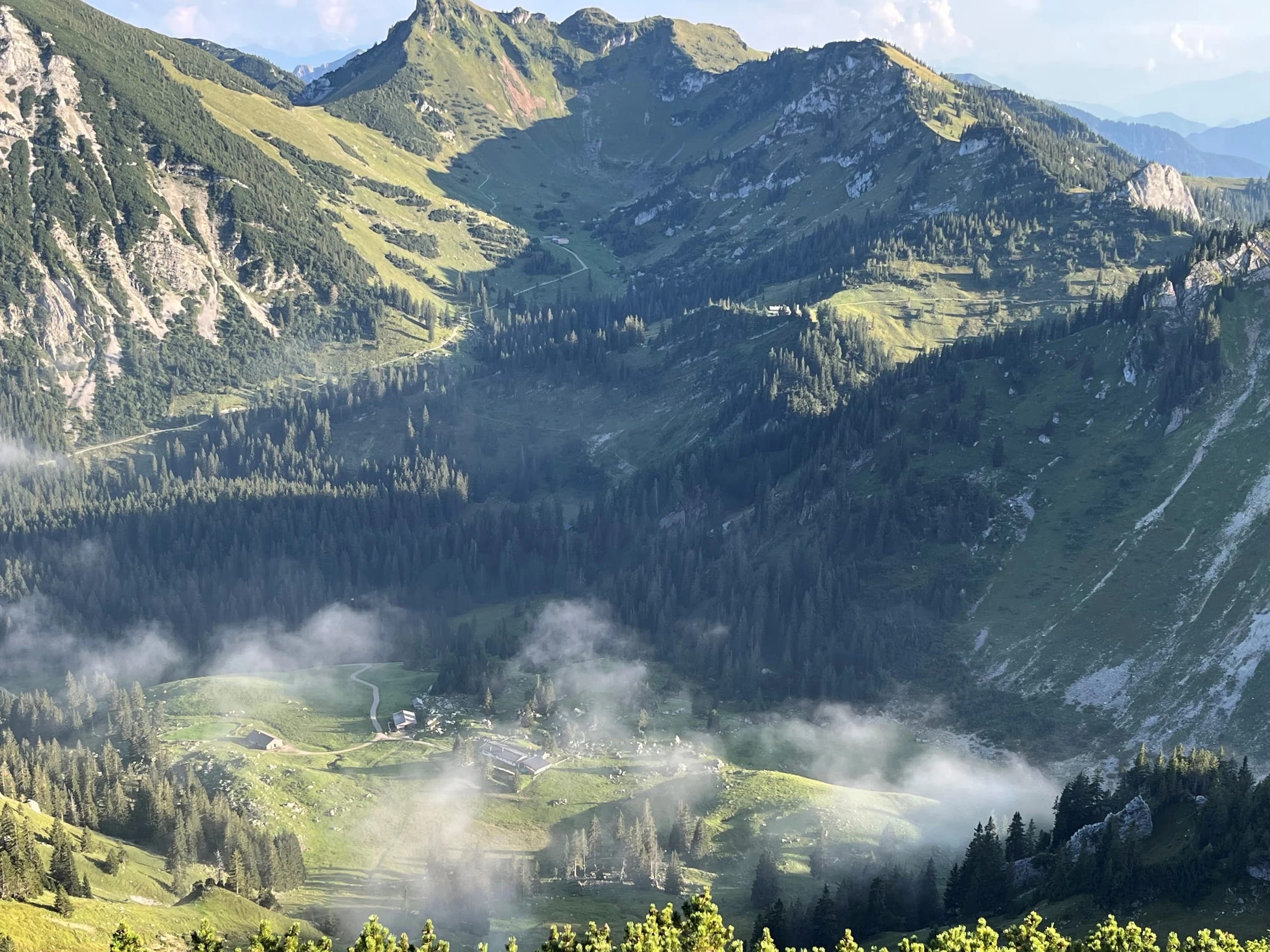 Weites Bergpanorama der Rotwand-Region mit Wolkenfetzen über dem Tal