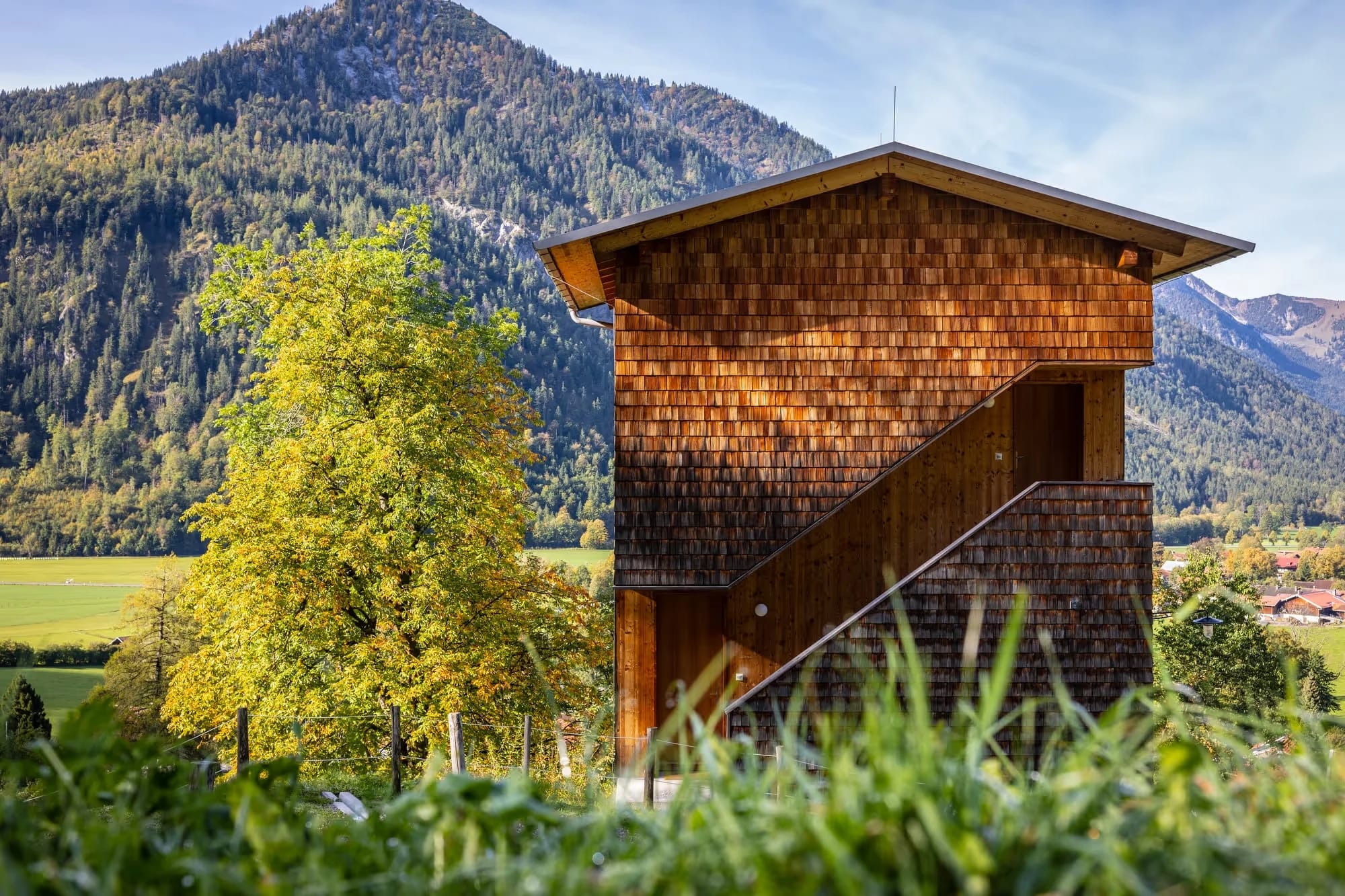 Hüttenturm des Tannerhof aus Holzschindeln in herbstlicher Alpenlandschaft mit Bergblick