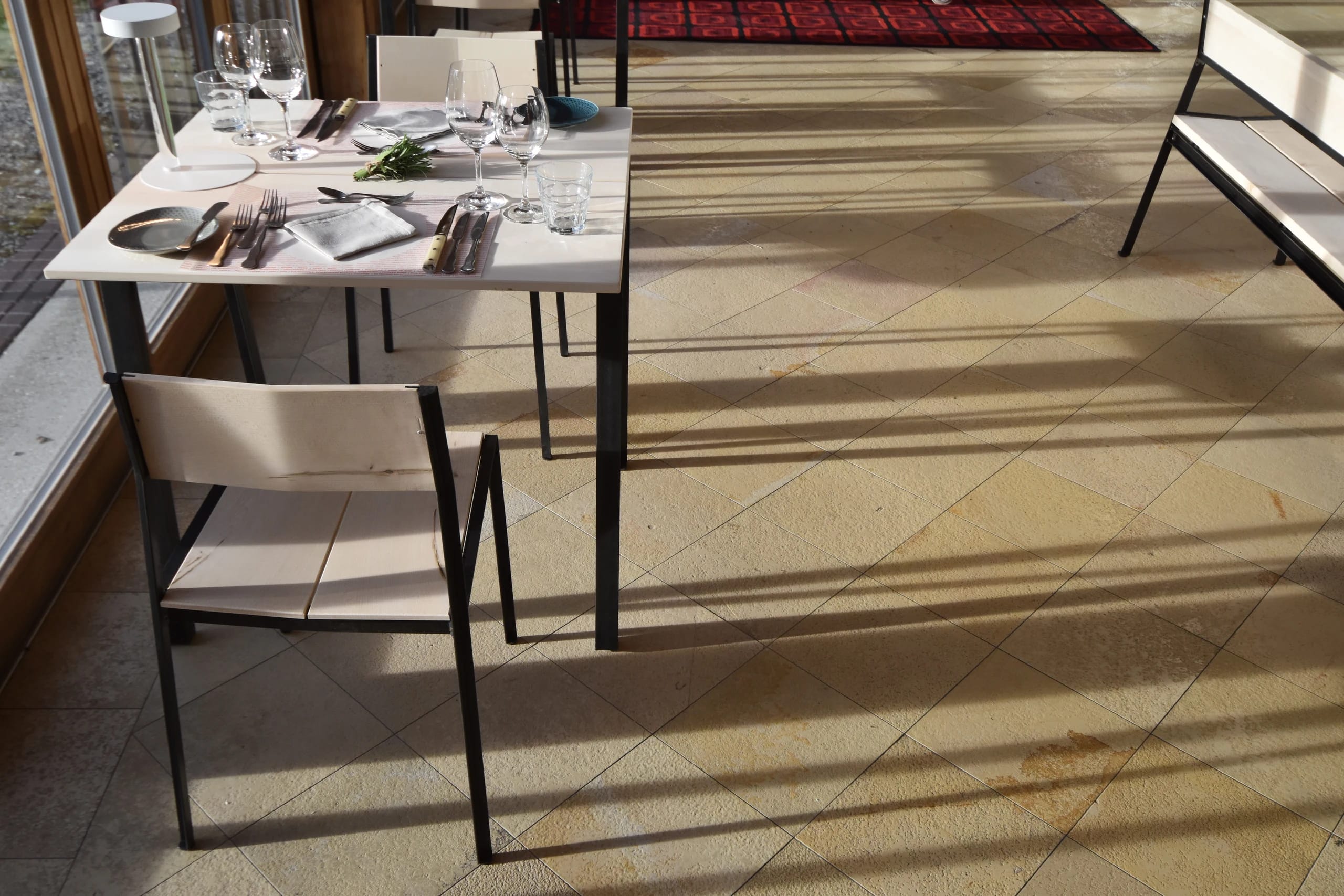 Gedeckter Tisch am Fenster im Restaurant des Tannerhof mit Natursteinboden und Tageslicht