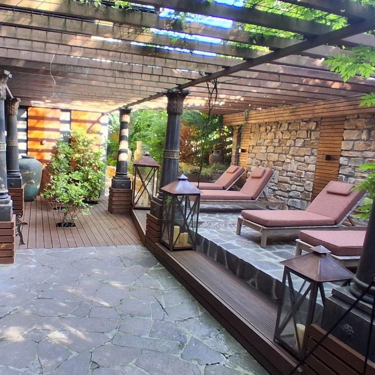 Überdachte Sitzecke mit Liegestühlen auf der Terrasse