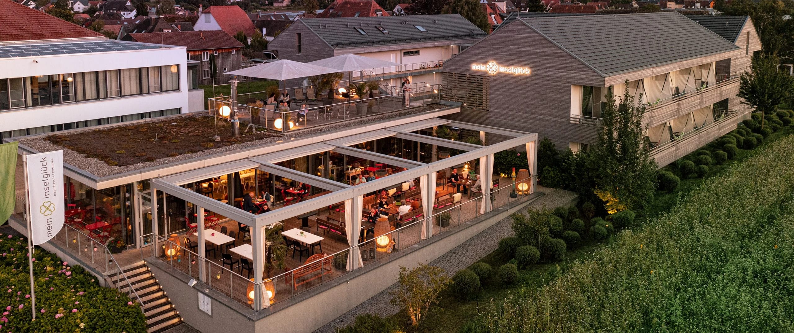 Außenansicht des Hauses in der Abenddämmerung mit beleuchteter Terrasse