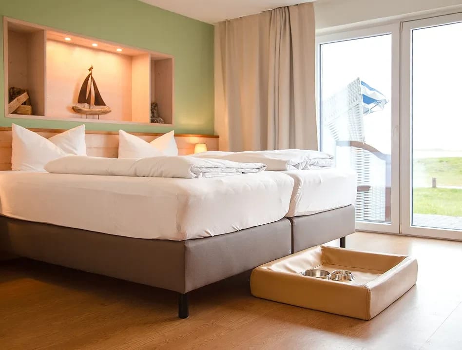Hundefreundliches Zimmer mit zwei Betten, Hundekörbchen und Terrassentür ins Grüne