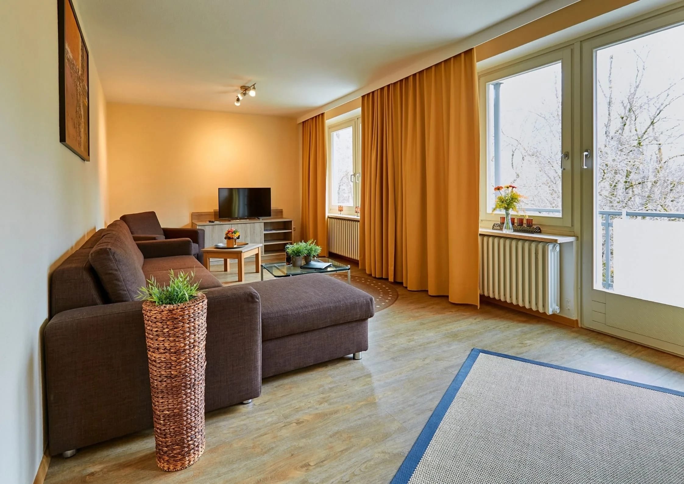 Wohnzimmer einer Ferienwohnung mit Sofa und Balkontür