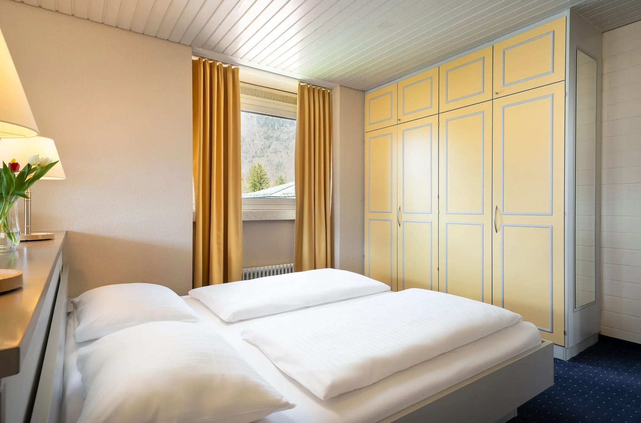 Schlafzimmer mit Doppelbett und hellem Kleiderschrank