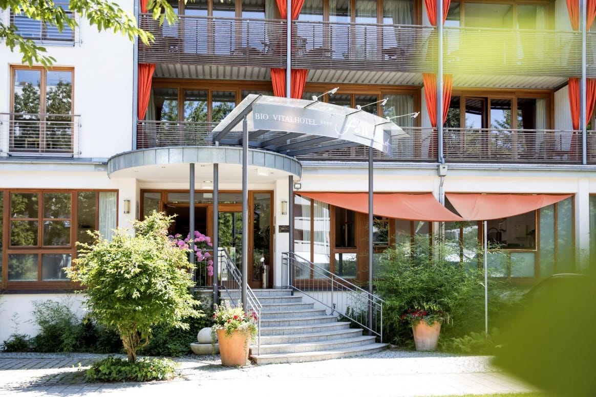 Hoteleingang mit überdachtem Treppenaufgang und Bepflanzung