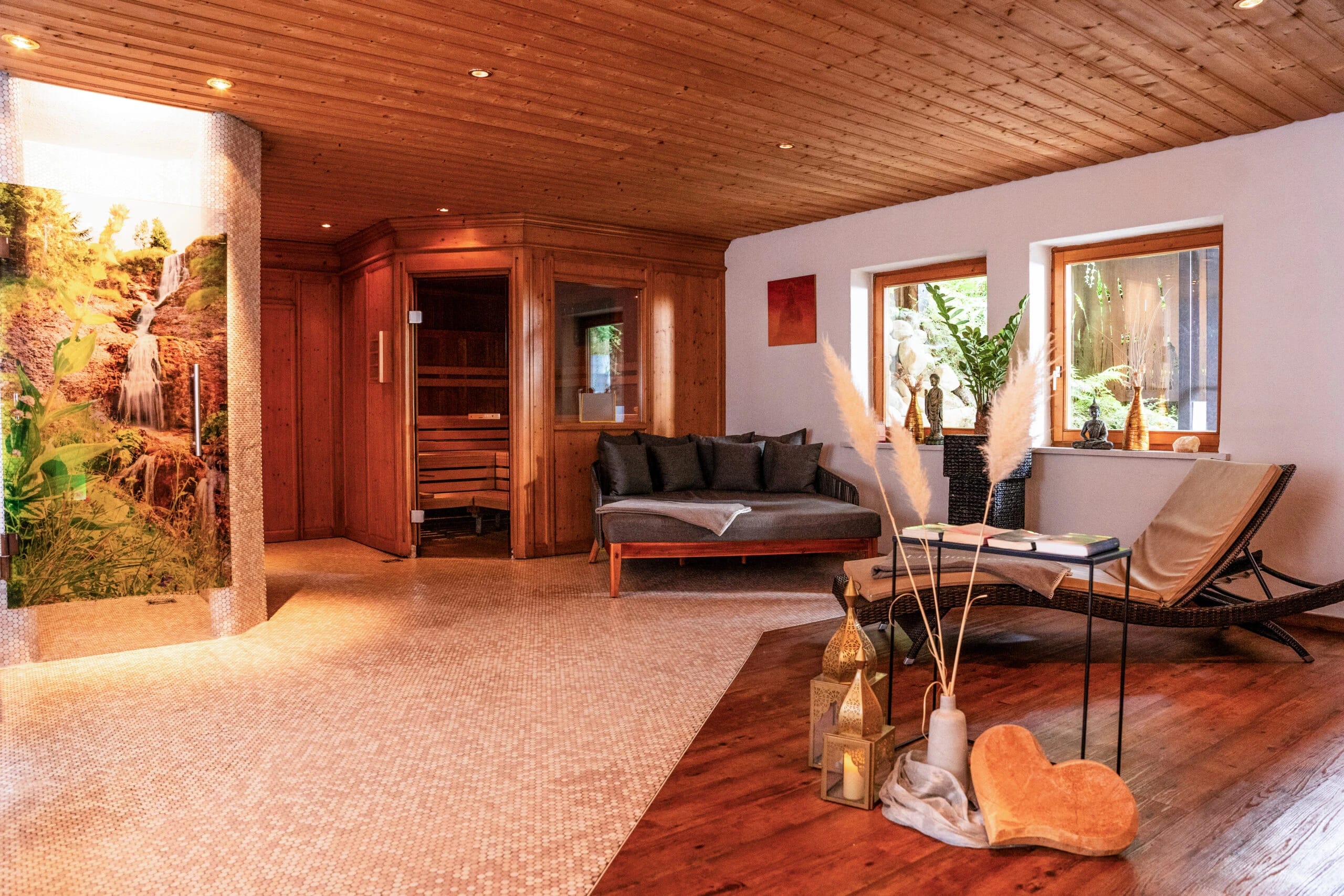 Ruheraum mit Saunakabine aus Holz, Sofa, Relaxliege und Holzdecke