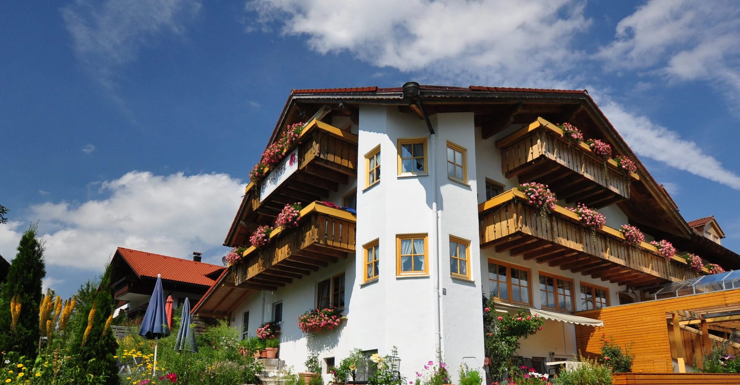 Gastgeberhaus im Allgäu mit Holzbalkonen und Blumenkästen