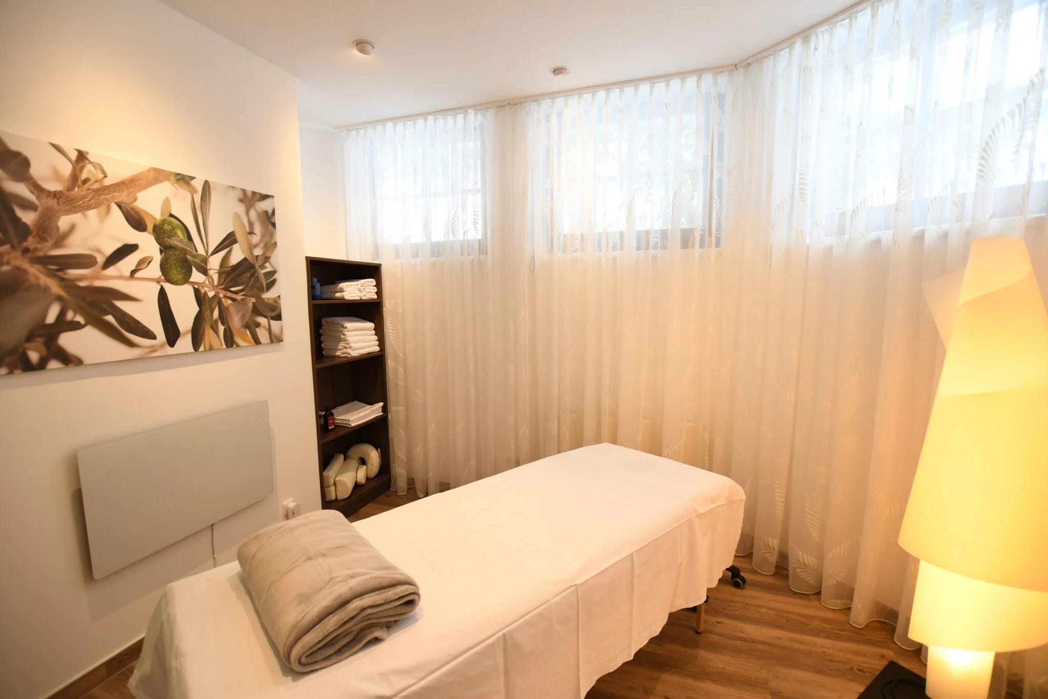 Behandlungsraum mit Massageliege und Vorhängen