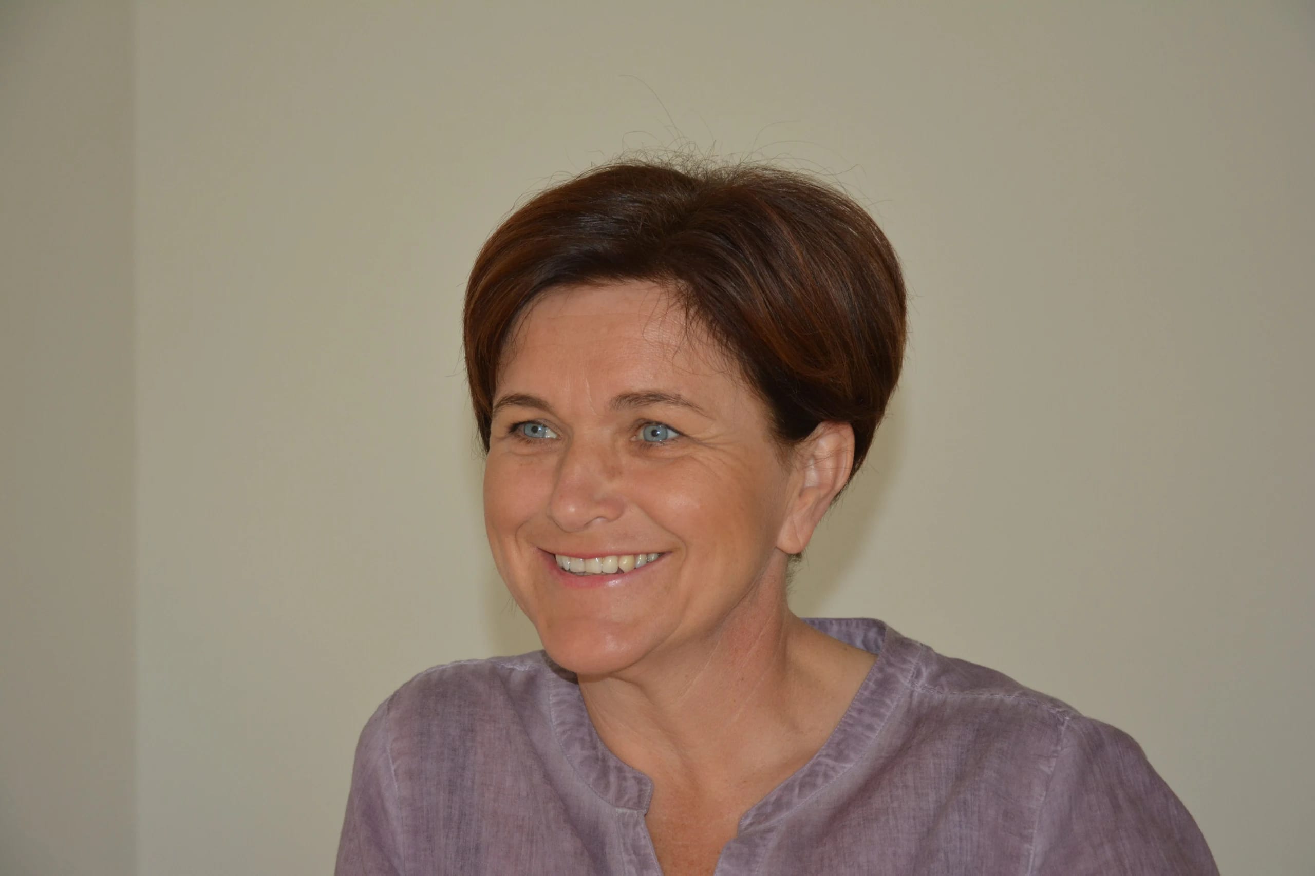 Porträt von Luise Eckhart-Wöllkart, lächelnd vor neutralem Hintergrund