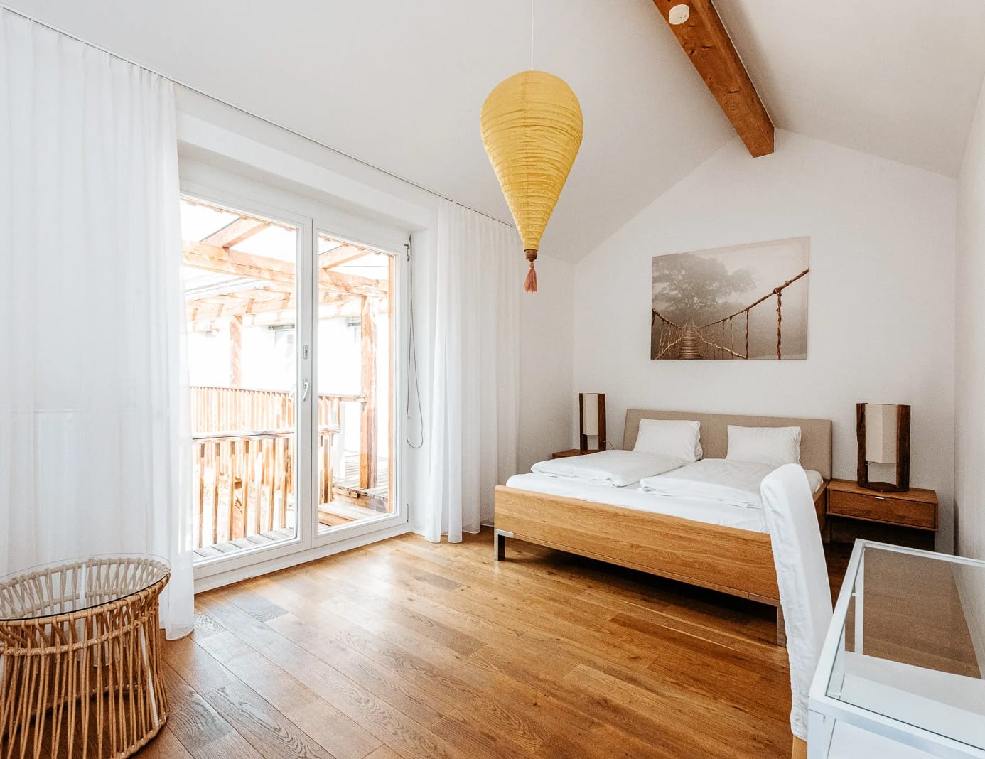 Helles Zimmer mit Holzboden, Doppelbett und Balkontür