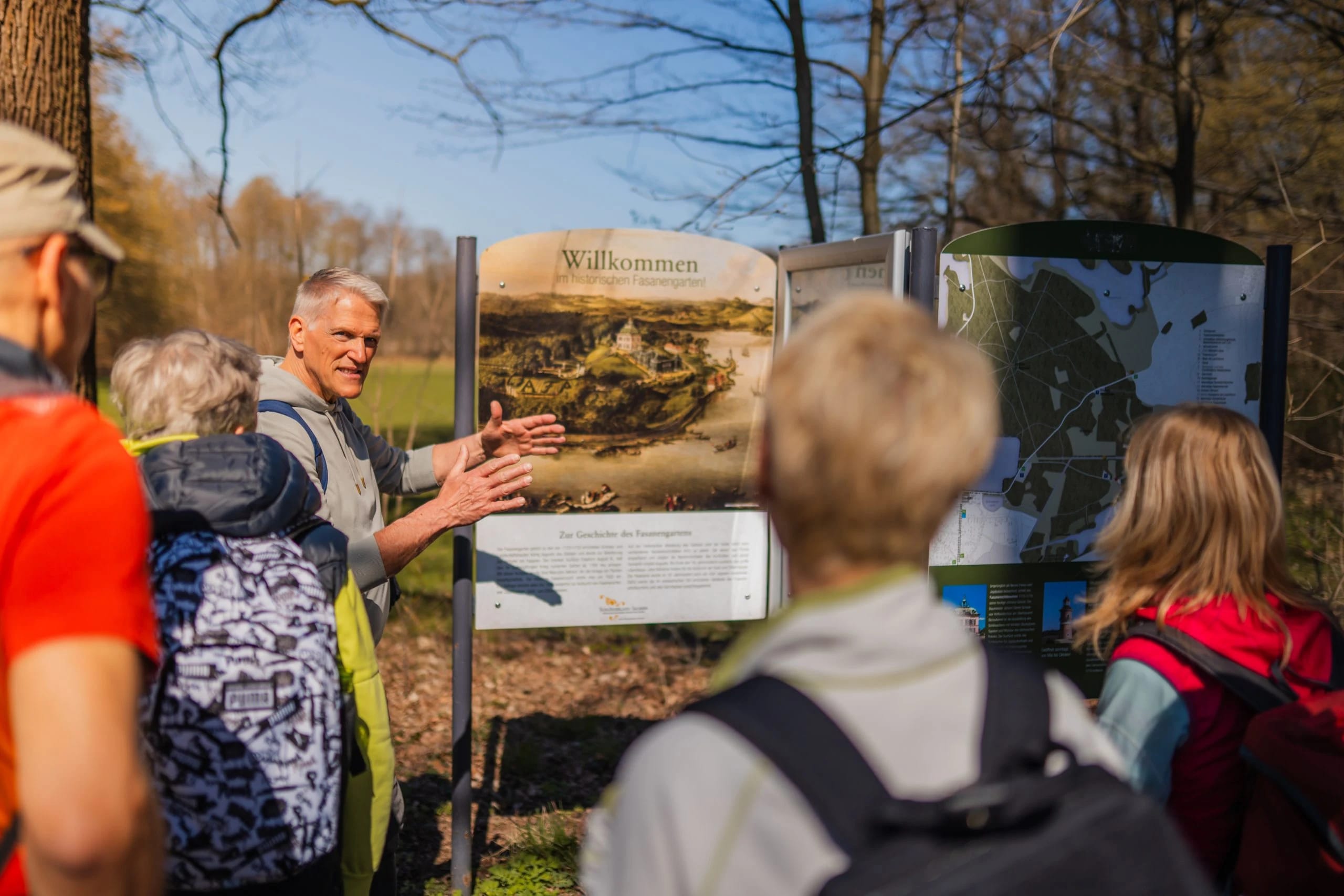 Michael Birkner erklärt einer Wandergruppe eine Infotafel am Wegesrand