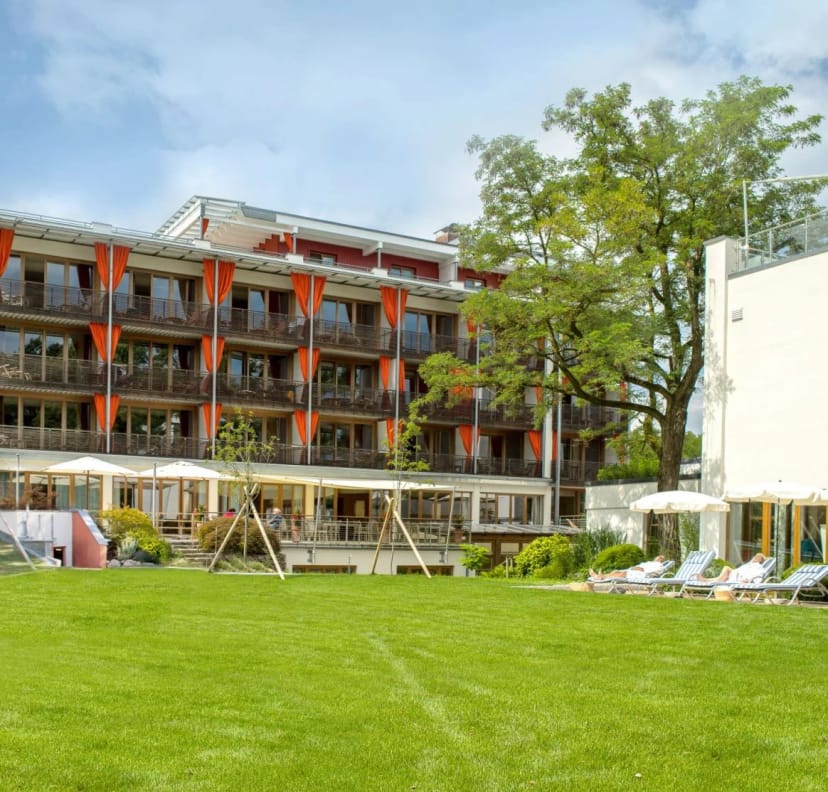 Außenansicht des Bio Thermalhotel Falkenhof mit Balkonen, Terrasse und Gartenwiese