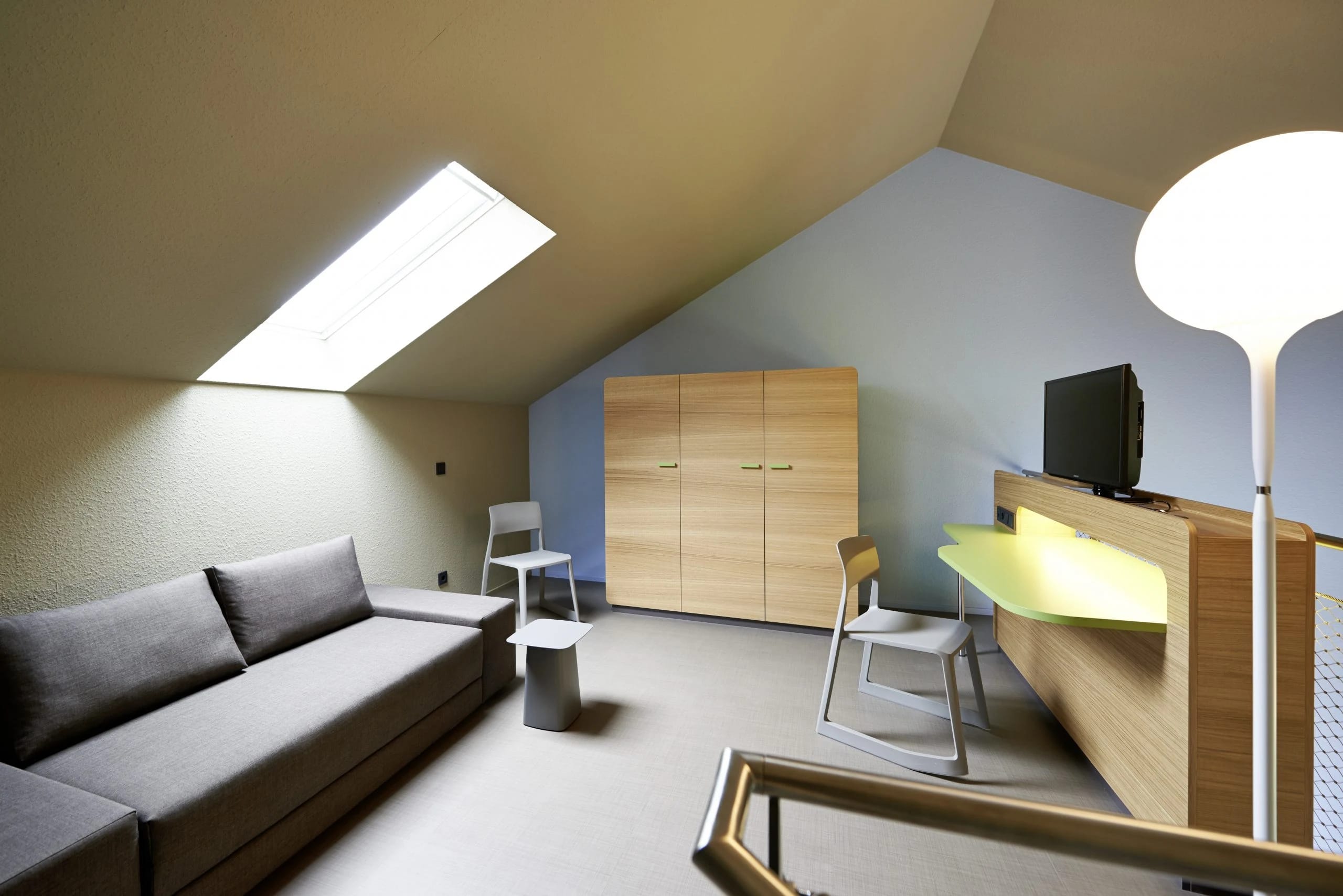 Helle Maisonette-Suite mit Doppelbett und offener Holztreppe