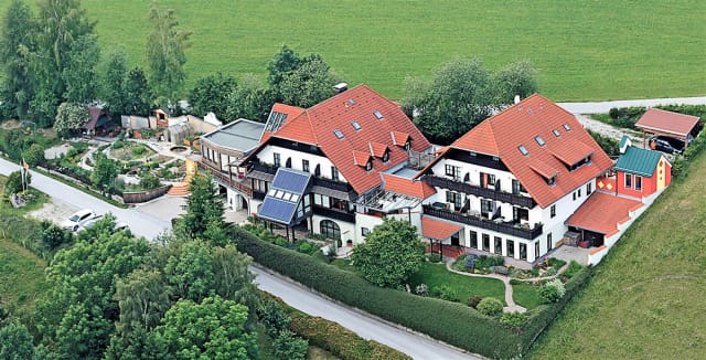 Luftaufnahme des Fastenhauses mit roten Ziegeldächern und angrenzenden Wiesen
