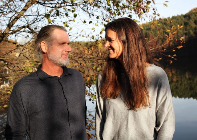 Heidi Allesch und Martin Weissböck lachen sich am Ufer des Weissensees im Herbstlaub an