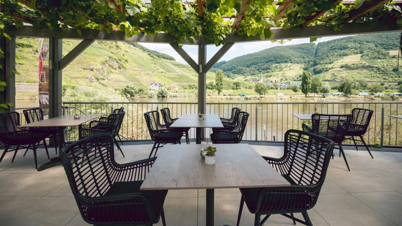 Terrasse unter Weinlaub mit Blick über die Mosel auf die Weinberge