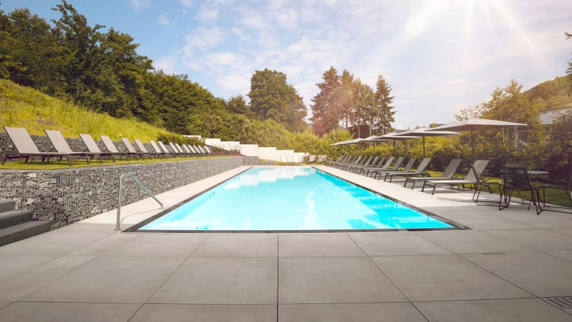 Spa-Bad mit freistehender Badewanne vor Natursteinwand