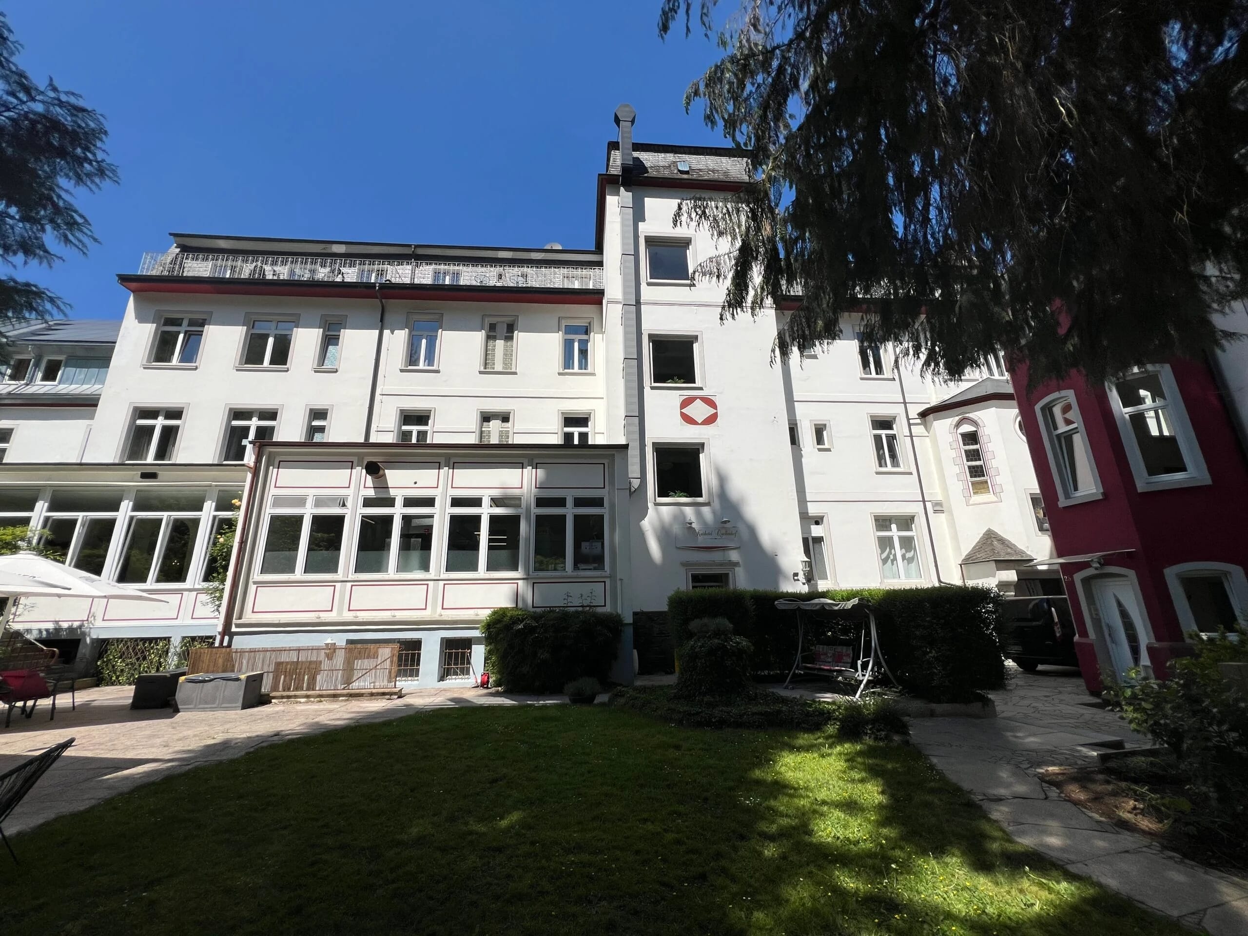 Rückseite des Hotels mit Wintergarten und Garten