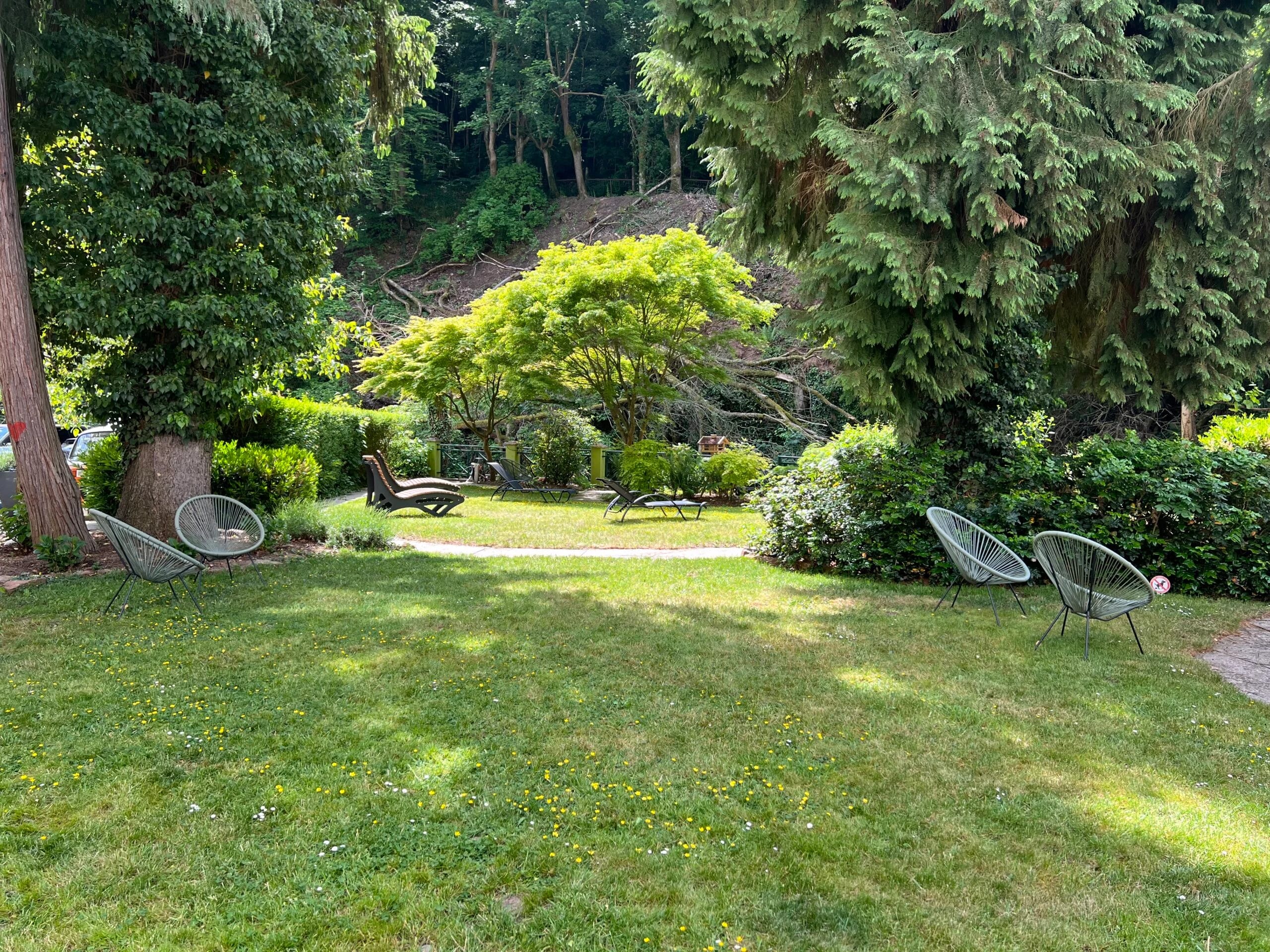 Gartenanlage mit Liegestühlen und Sitzgruppen im Grünen