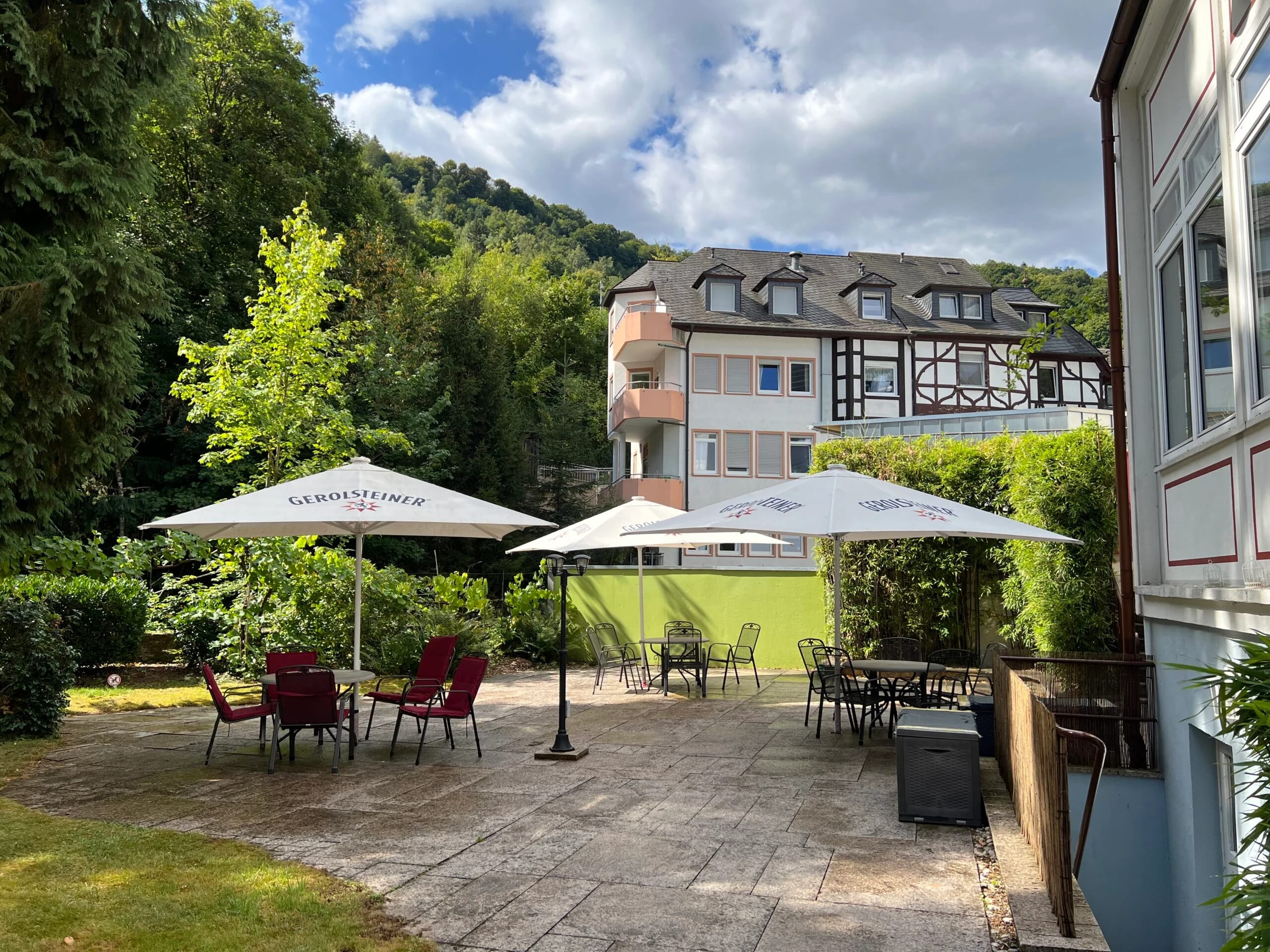 Terrasse mit Sonnenschirmen und Sitzgelegenheiten vor dem Haus
