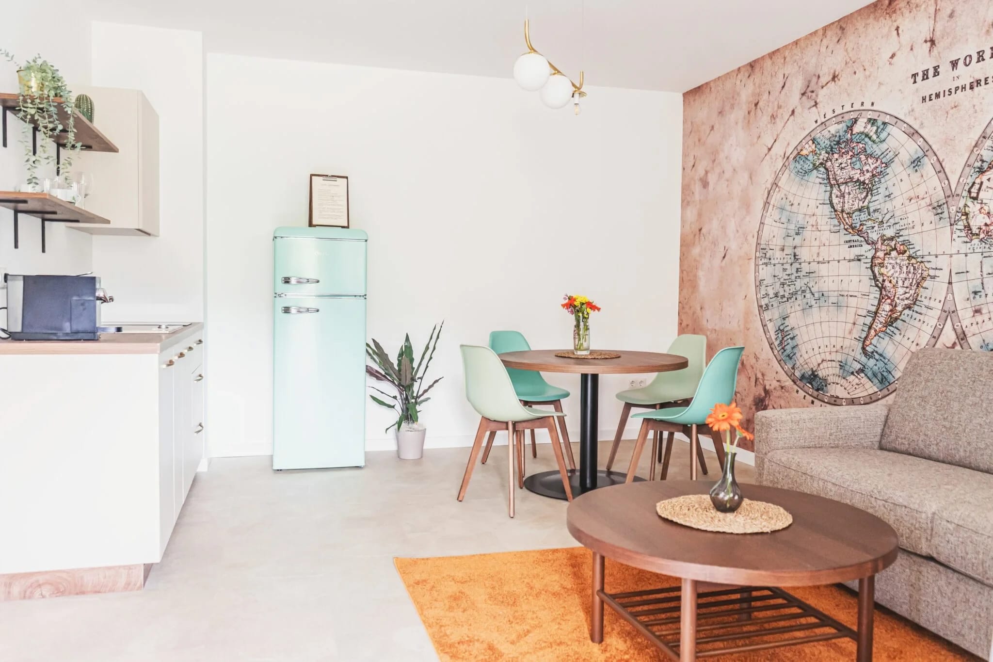 Appartement mit Küchenzeile, Retro-Kühlschrank, Esstisch und Weltkarten-Tapete