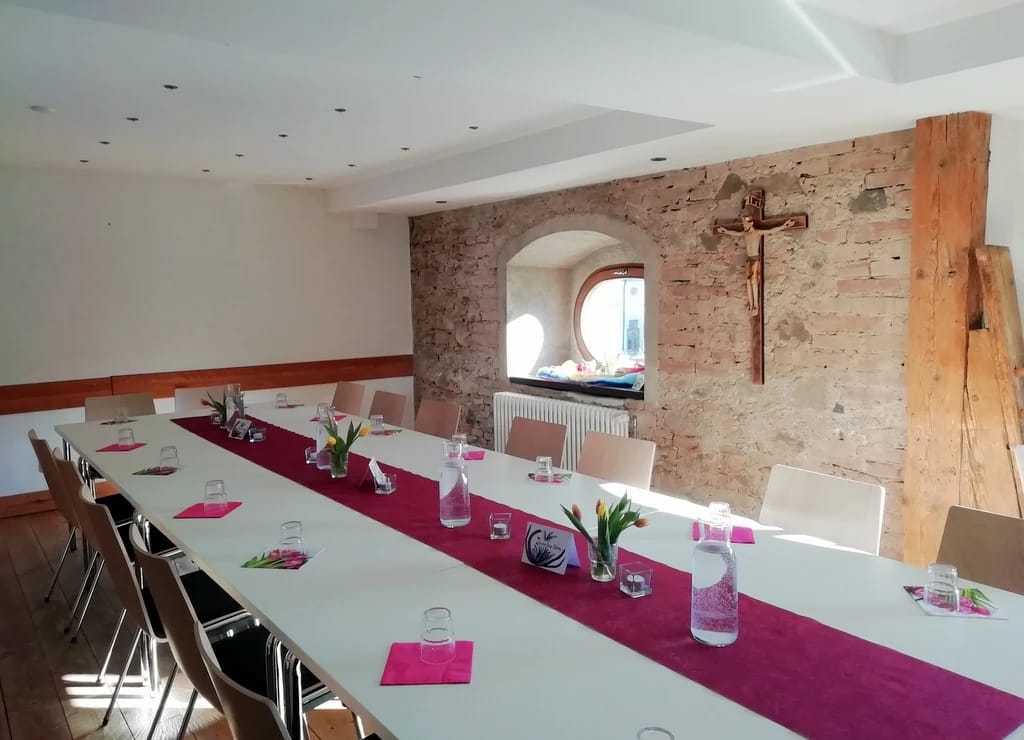Seminarraum mit gedeckter Tafel und Natursteinwand