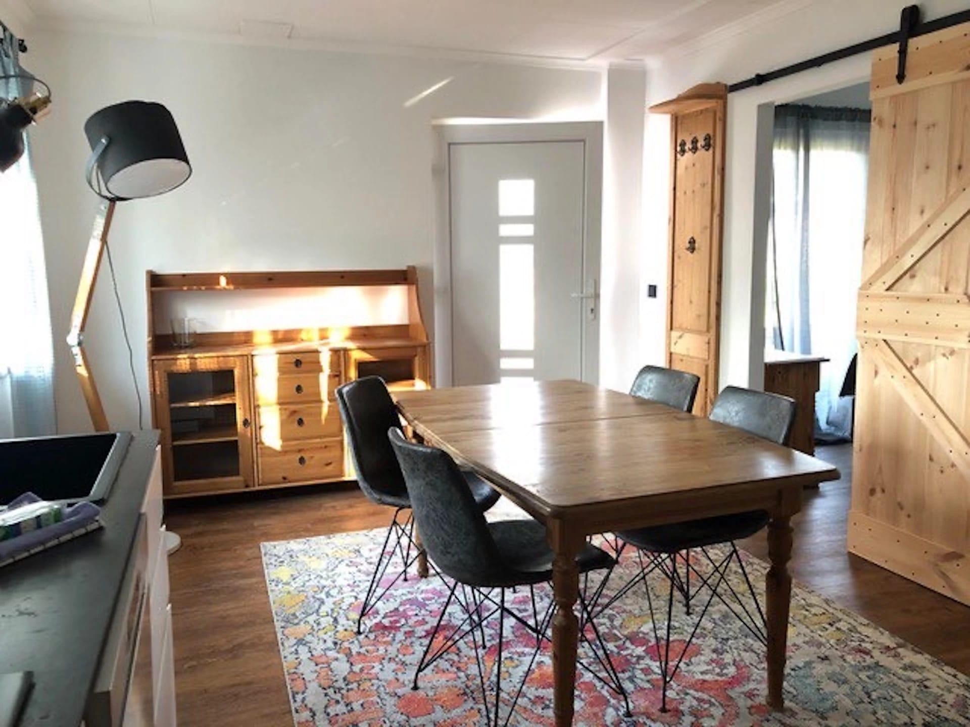 Essbereich im Ferienhaus mit großem Holztisch, Sideboard und Schiebetür