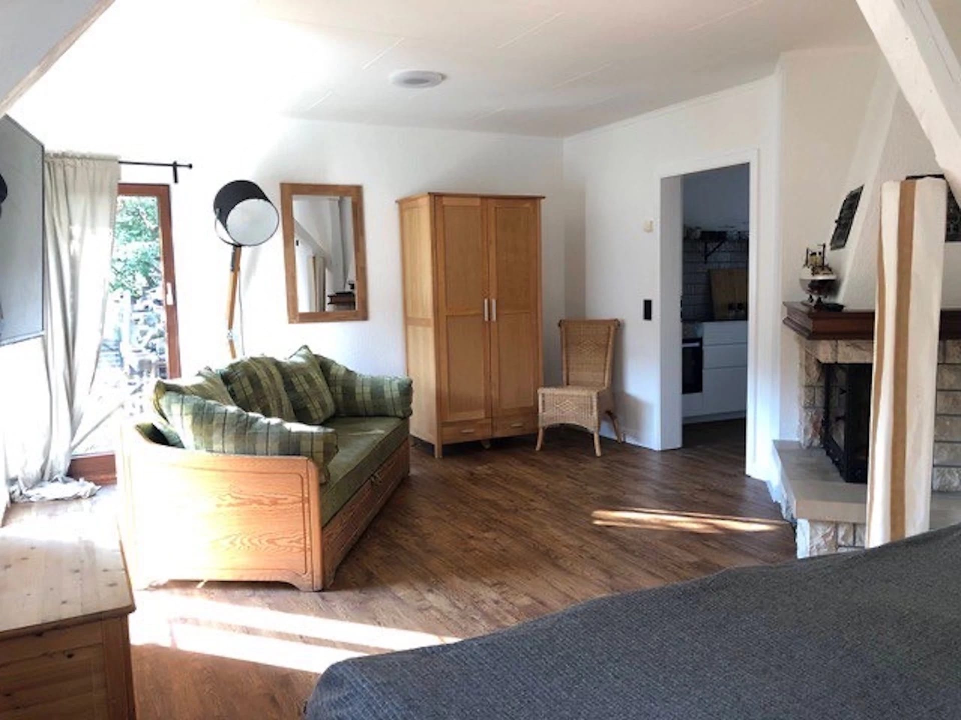 Wohnraum im Ferienhaus mit Sofa, Kleiderschrank und Kamin